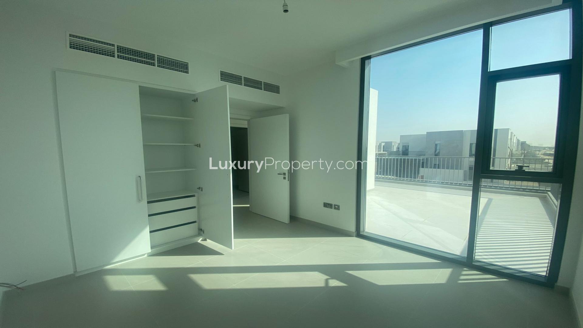 "Bright empty room with large windows in new villa, Arabian Ranches 3, Joy community.",Bright bedroom with built-in closet and balcony in Arabian Ranches 3 Villa, Joy