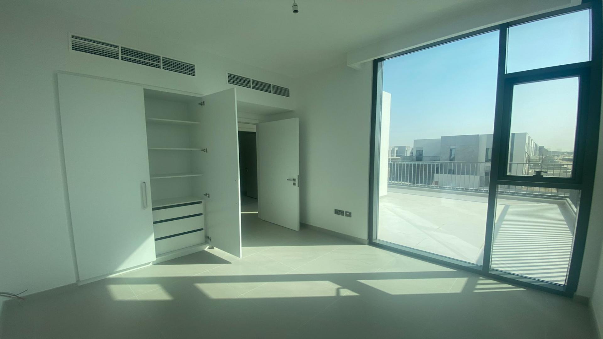"Bright empty room with large windows in new villa, Arabian Ranches 3, Joy community.",Bright bedroom with built-in closet and balcony in Arabian Ranches 3 Villa, Joy