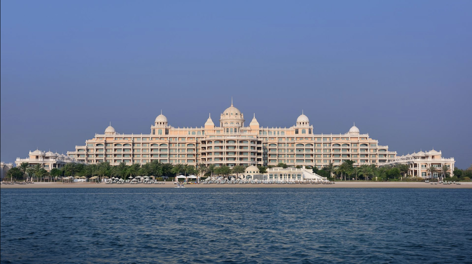 Luxurious villa exterior at Kempinski The Palm, Palm Jumeirah, surrounded by lush gardens