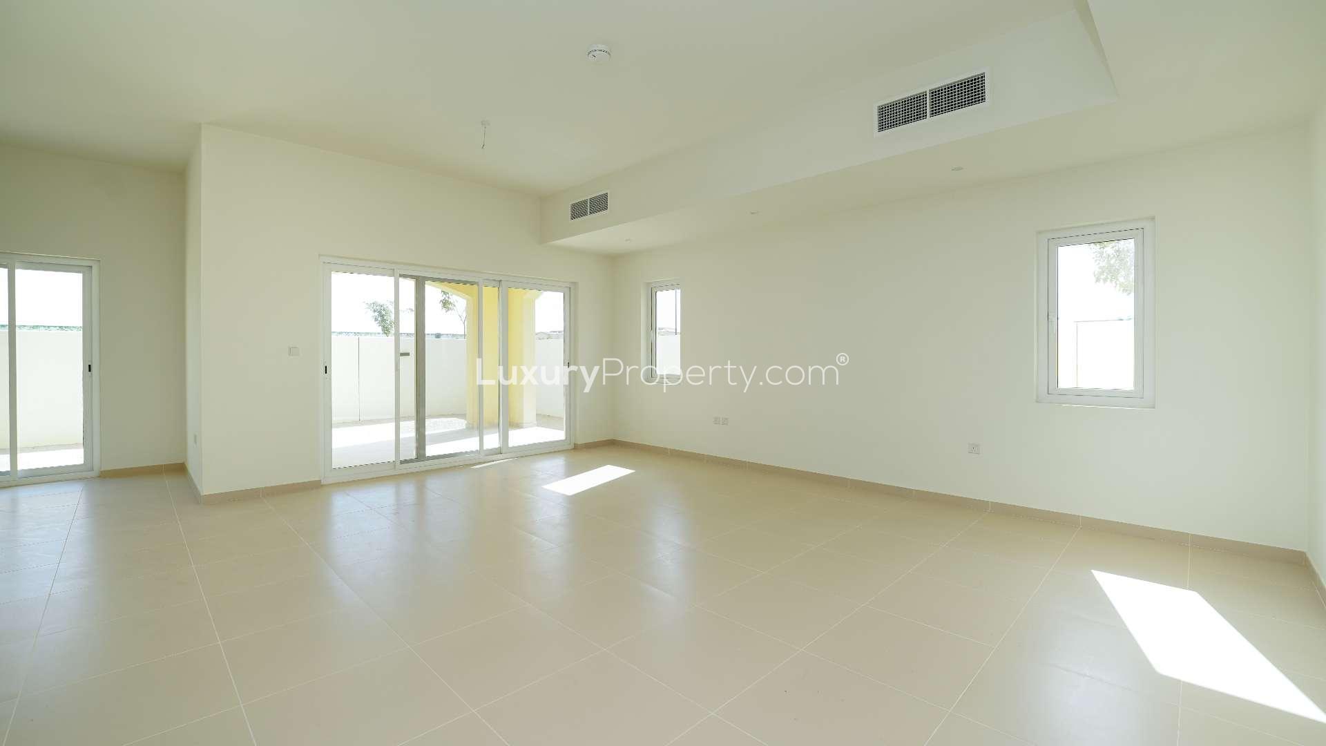 Spacious living area in Villanova villa, Dubai Land, with sliding doors to patio