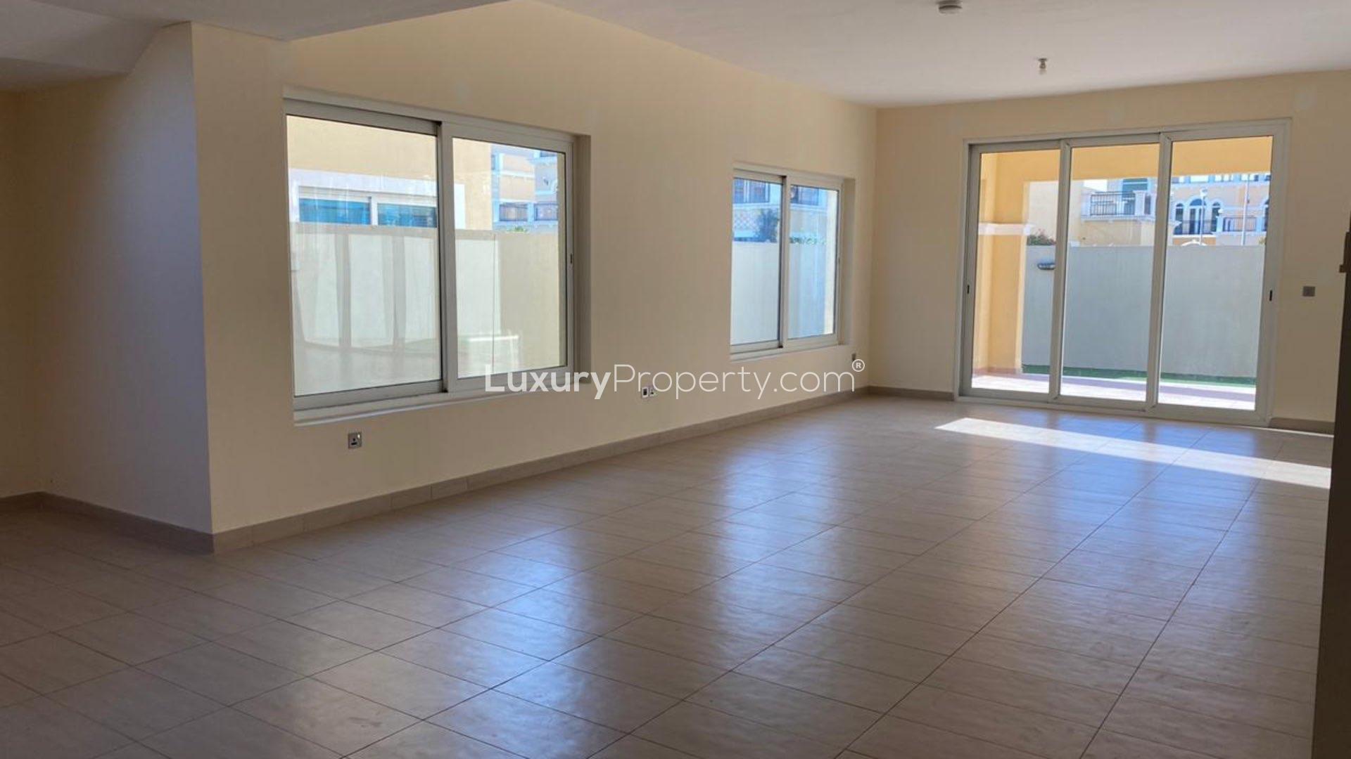 "Spacious backyard with green lawn at Jumeirah Park Legacy Nova Villa, Dubai.",Spacious living area in Jumeirah Park Legacy Nova Villa for sale, tiled flooring, large windows