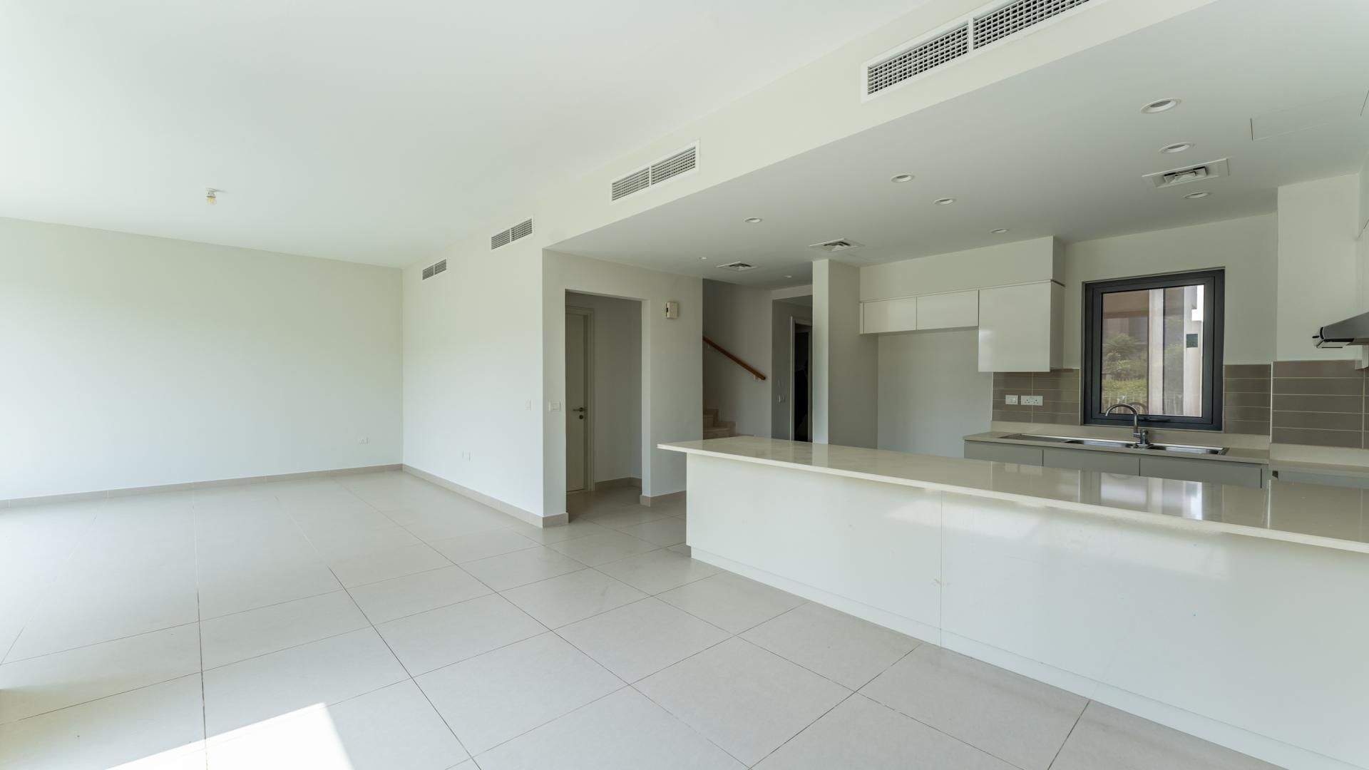 Bright living area in Maple Villa, Dubai Hills Estate, featuring large windows and modern kitchen