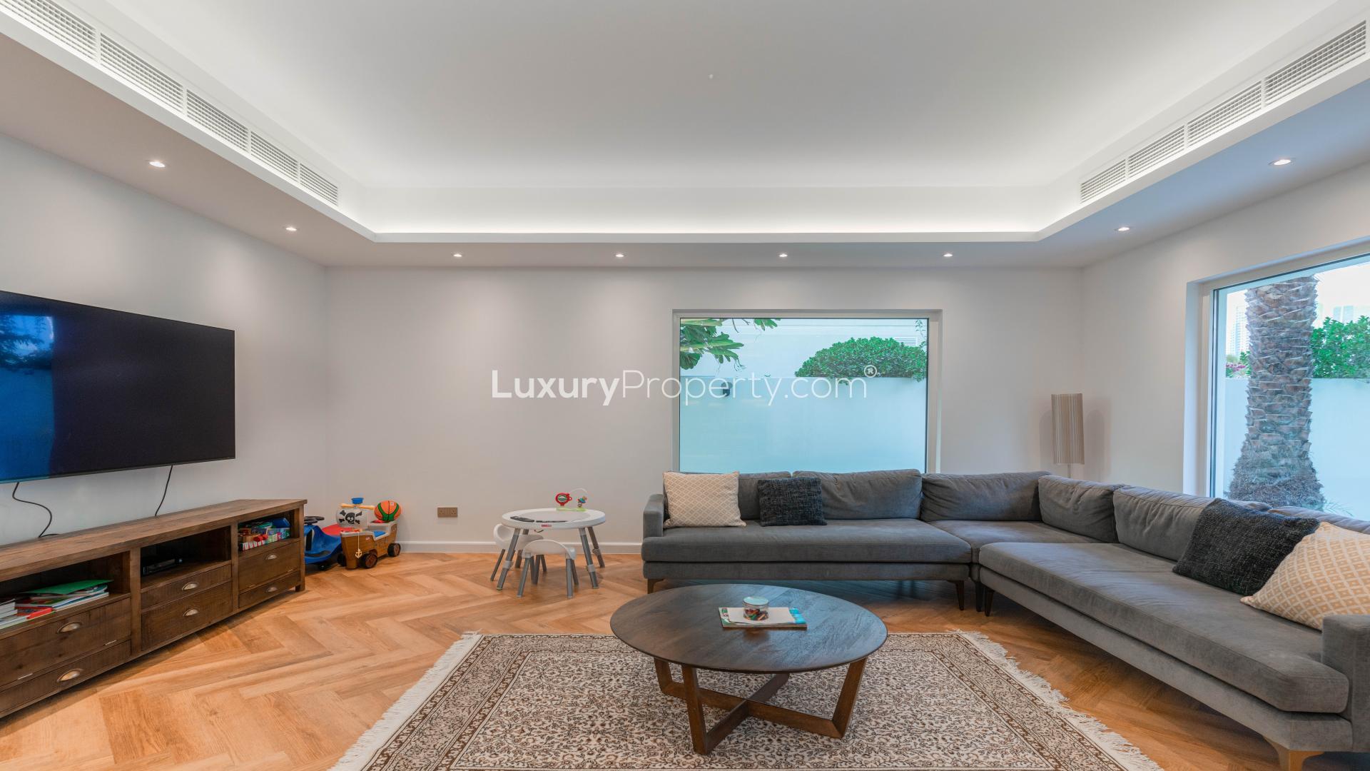 Living room in fully renovated villa, Meadows 2, featuring modern decor and garden view