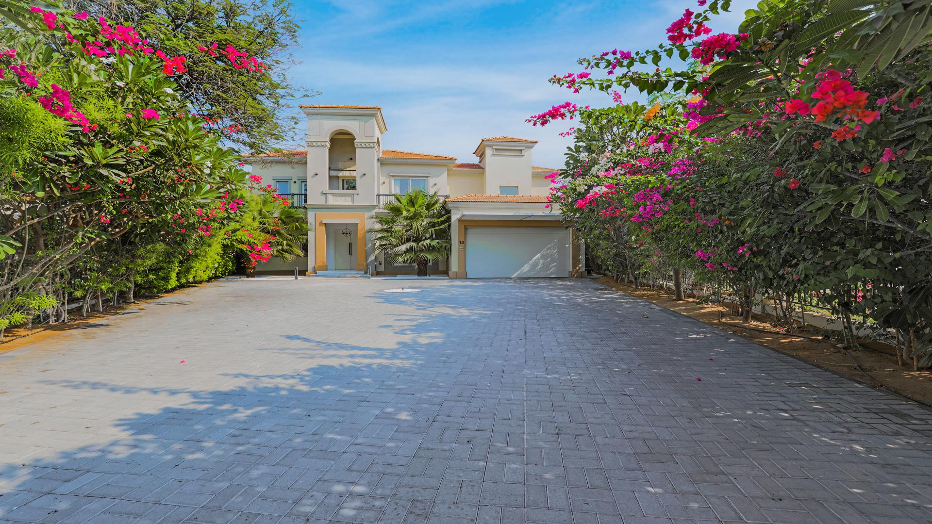 Elegant living room in four-bedroom villa, Jumeirah Islands, with modern decor and staircase