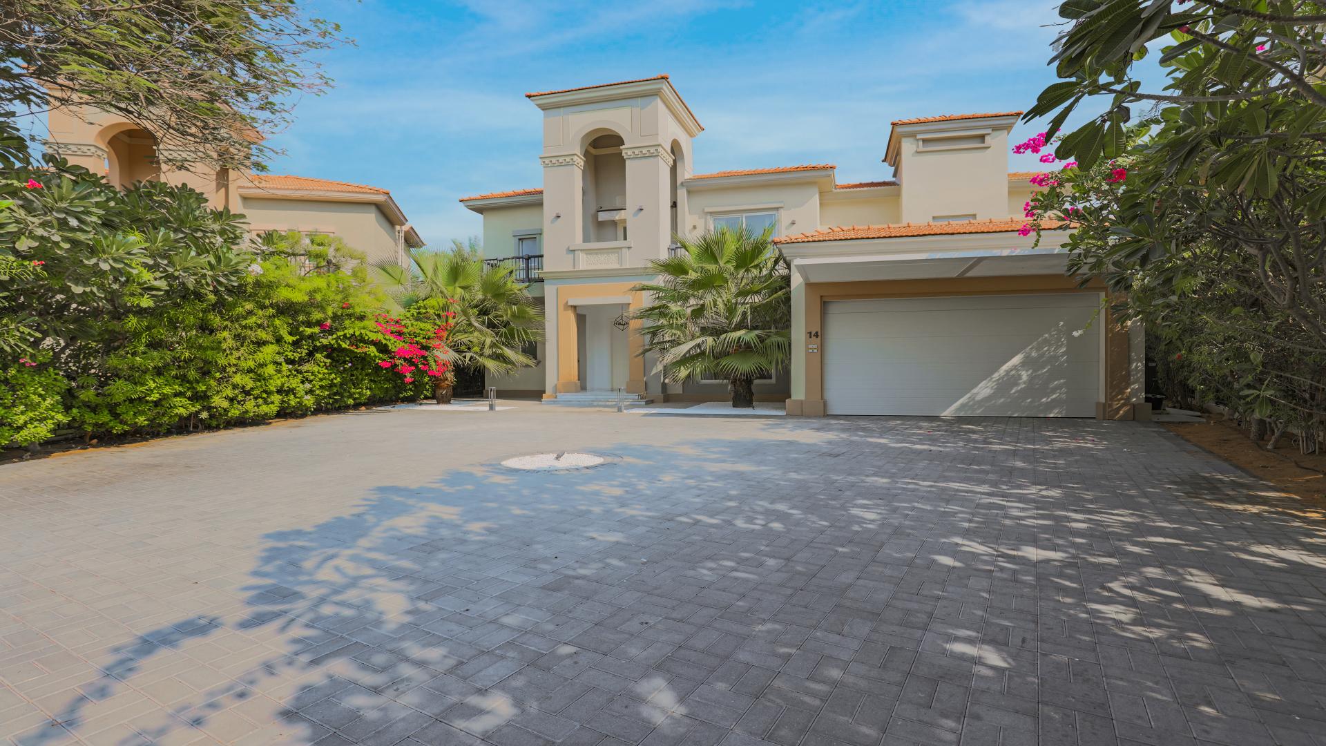 Elegant living room in four-bedroom villa, Jumeirah Islands, with grand piano and garden view