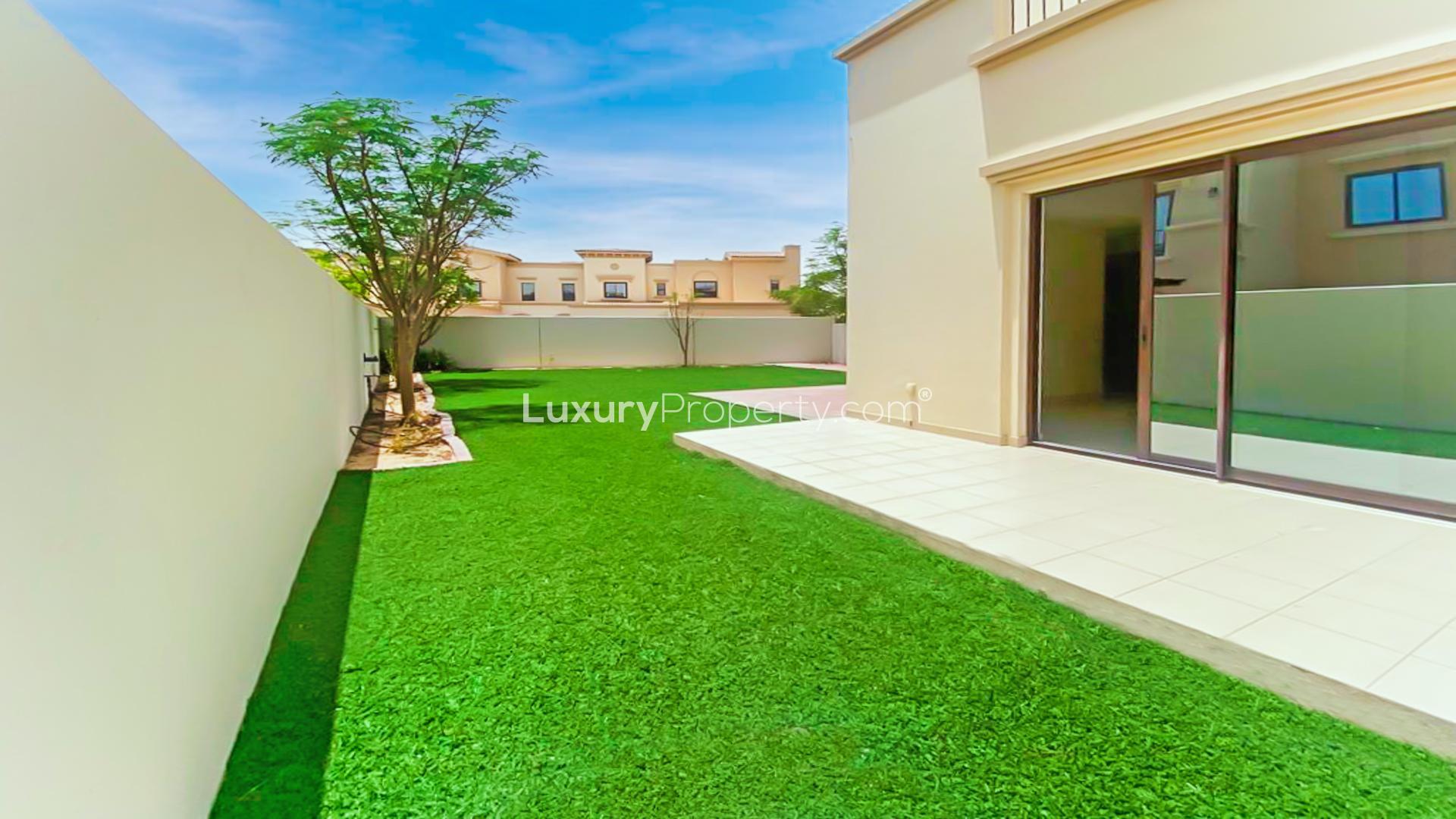 "Spacious villa garden with patio in Mira, Reem community, available for rent.",Alt text: "Spacious balcony view of Mira villa with lush garden, Reem community, LP12786.",Modern kitchen with wooden cabinets in a 3-bedroom Mira villa for rent, Reem community