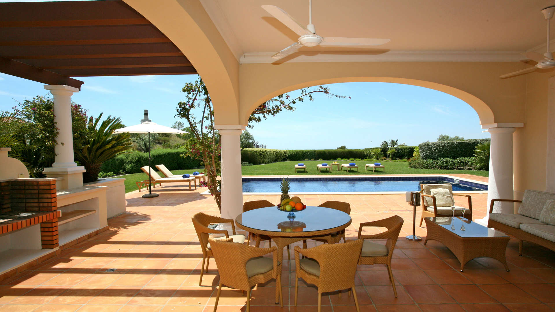 Elegant living room and dining area in Monte Rei villa, Algarve, Portugal with pool view
