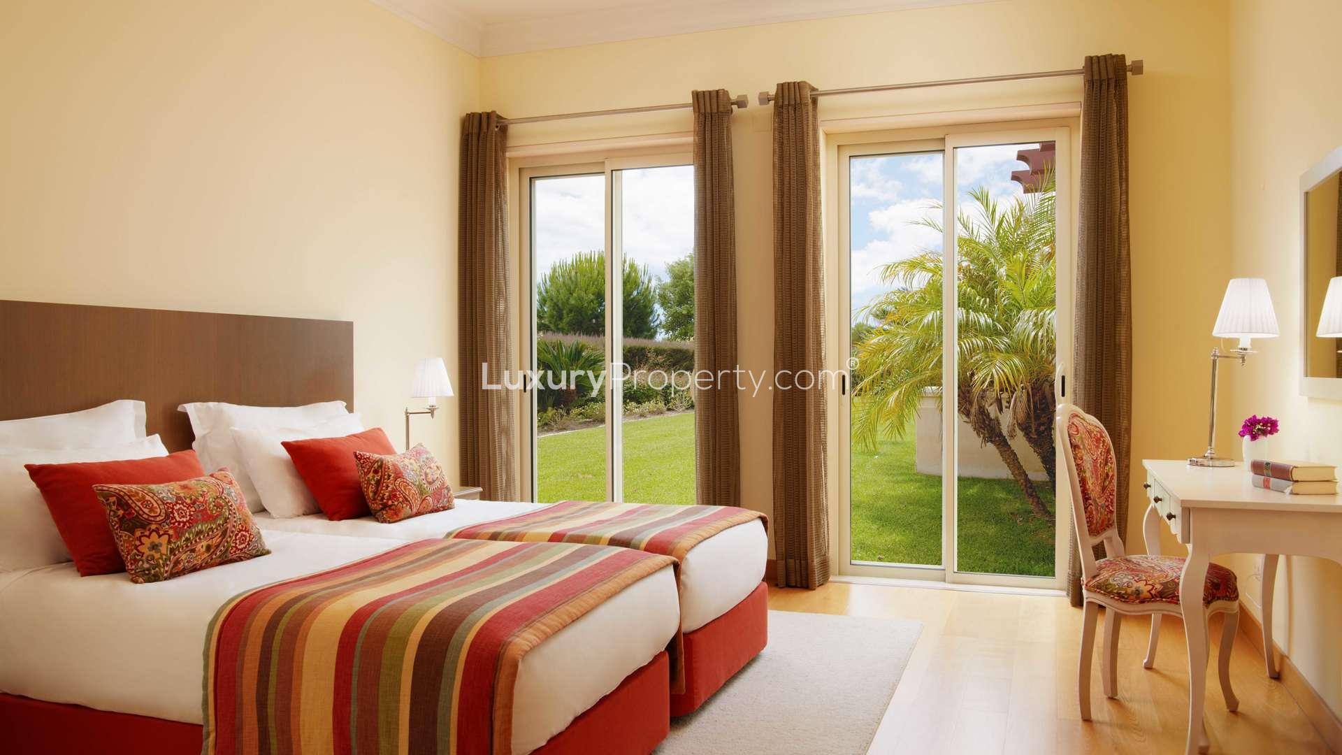 Elegant living and dining area in Monte Rei villa, Algarve, with pool view