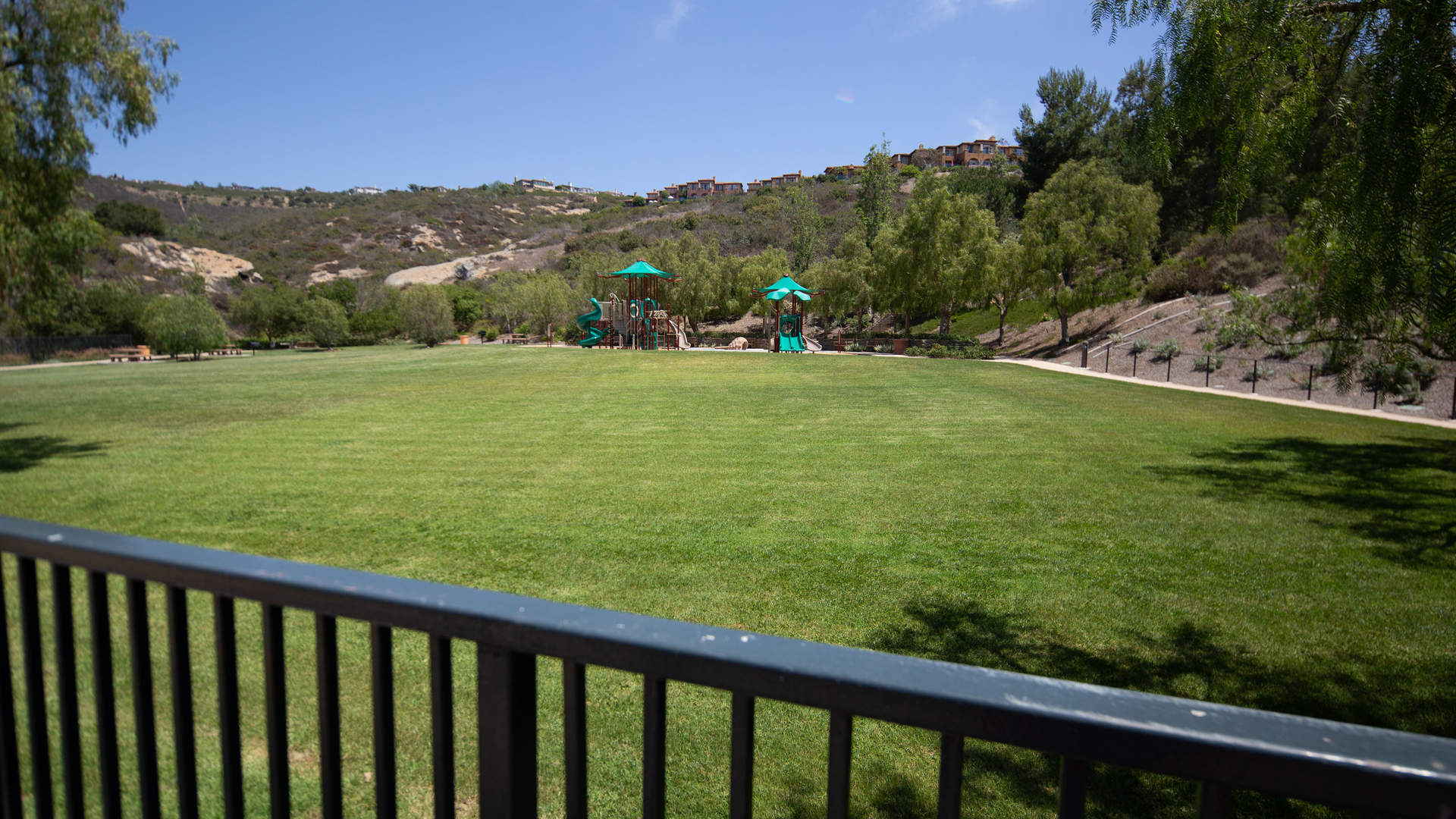 Lush garden view of Newport Coast villa with palm trees and patio seating area
