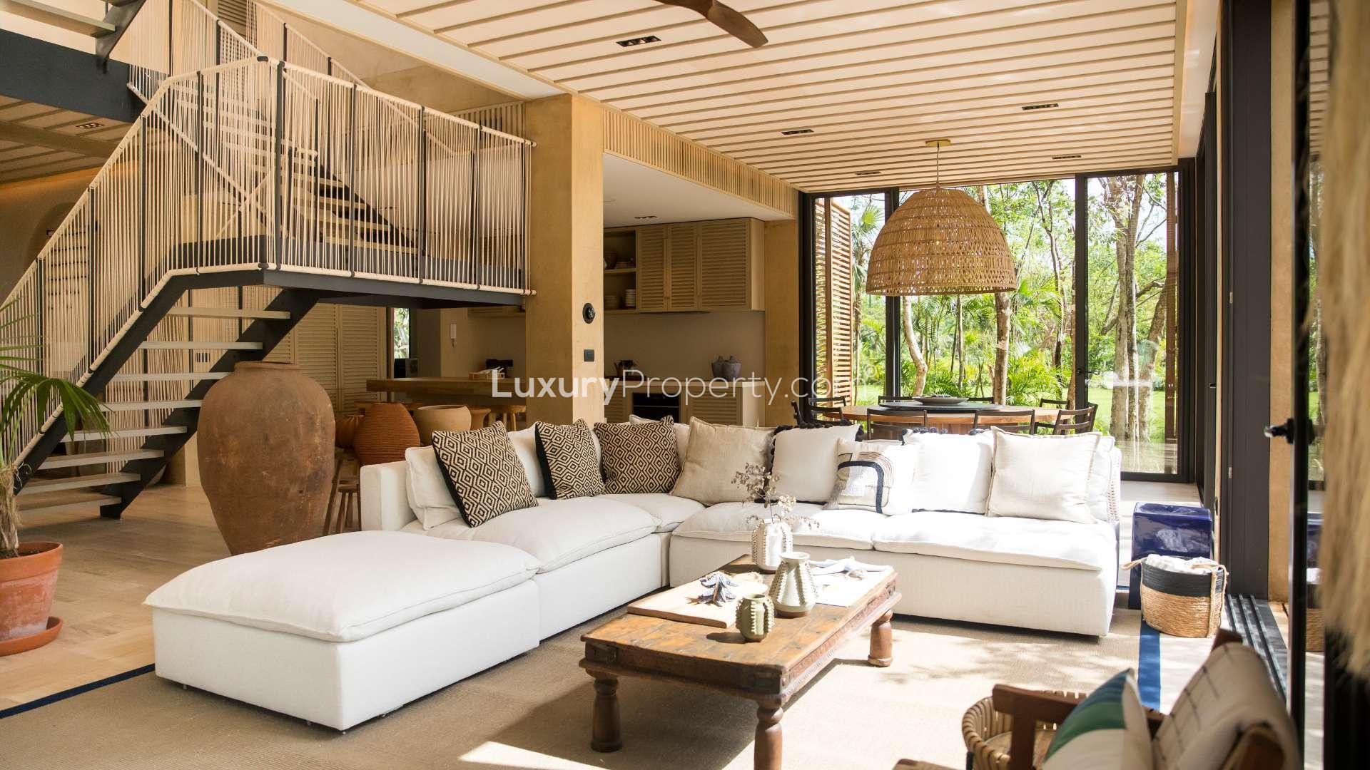 Luxurious living room in Corasol Riviera Maya villa with modern decor and garden views