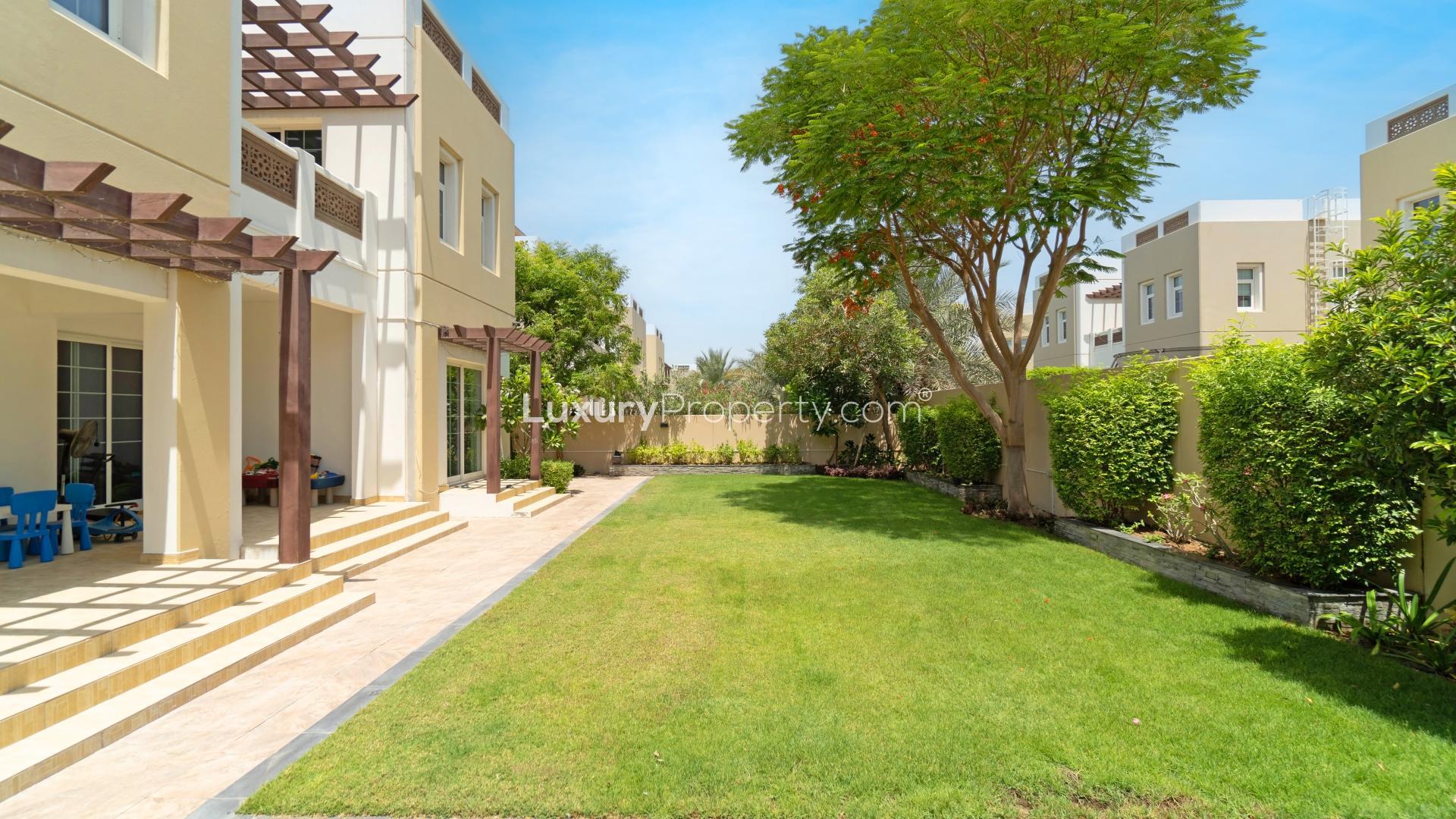 Front entrance of 4-bedroom villa in Mudon, Dubai with lush garden and pathway