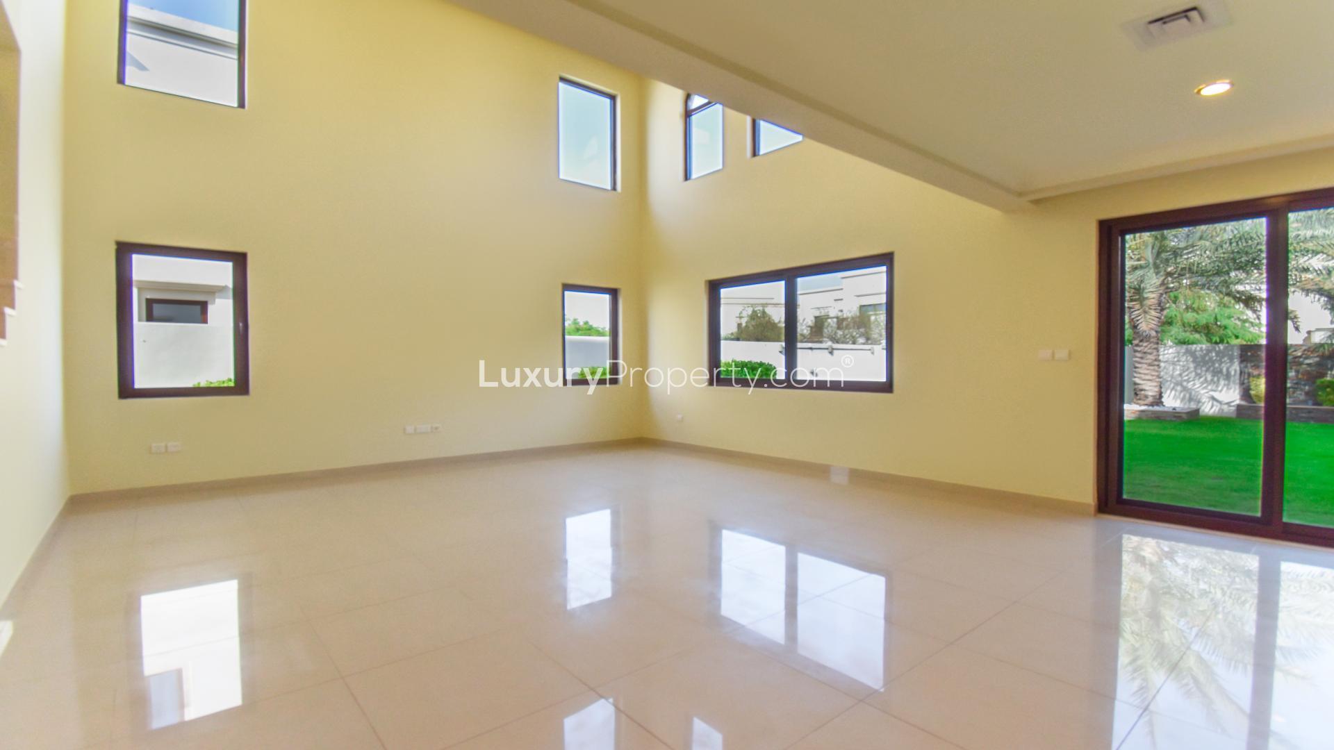 "Spacious 4-bedroom villa in Arabian Ranches 2, Rasha community, for sale near park and pool.",Spacious living room in Type 2 villa, Arabian Ranches 2, with large windows and garden view