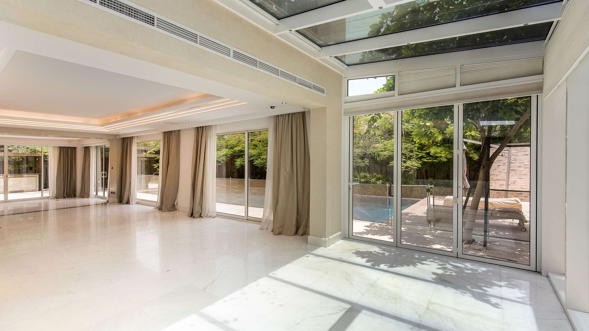 Luxurious living room with glass doors and pool view in Saadiyat Beach villa, Abu Dhabi