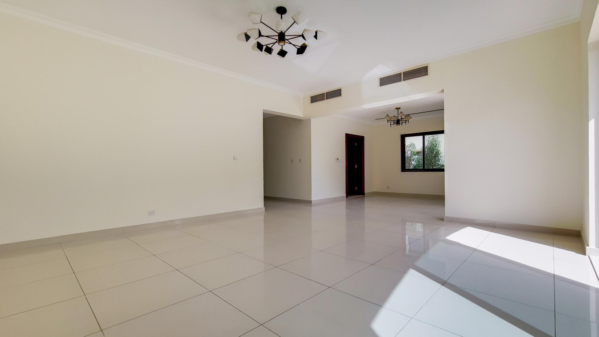 Spacious living room in Arabian Ranches 2 Samara villa with elegant lighting and tiled flooring