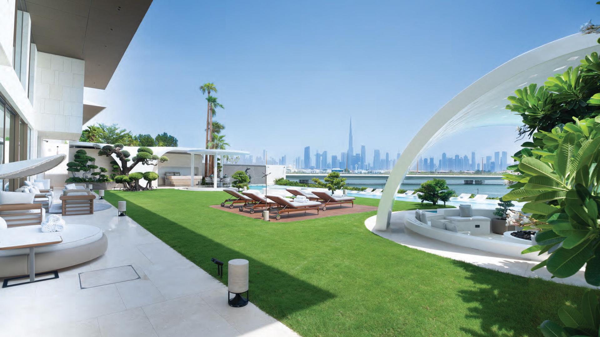N/A,Luxurious beachfront villa with stunning skyline view, lush garden, and modern outdoor seating in Jumeirah
