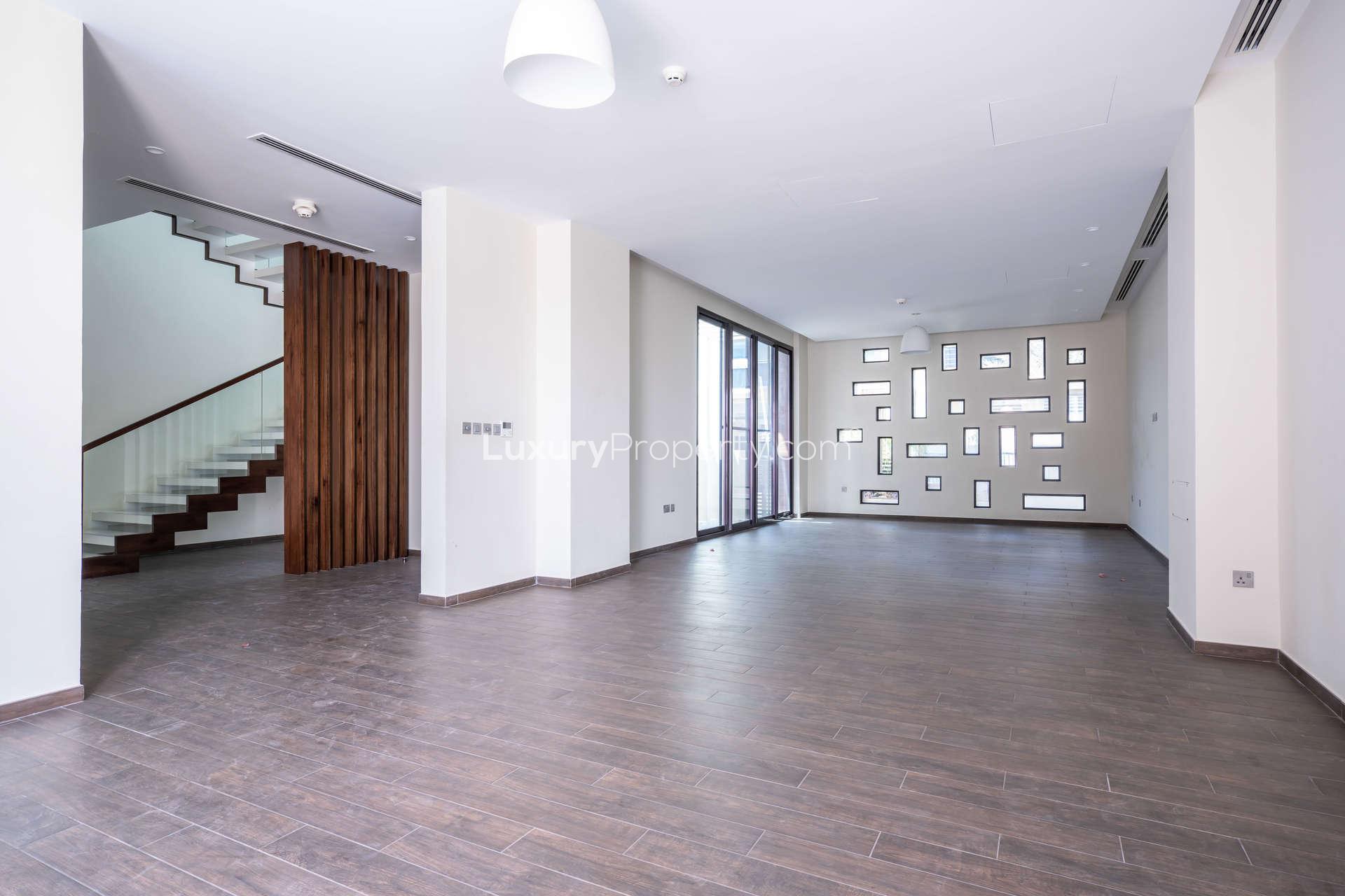 Modern kitchen interior in 4-bedroom villa, Umm Suqeim 2, with large windows and island