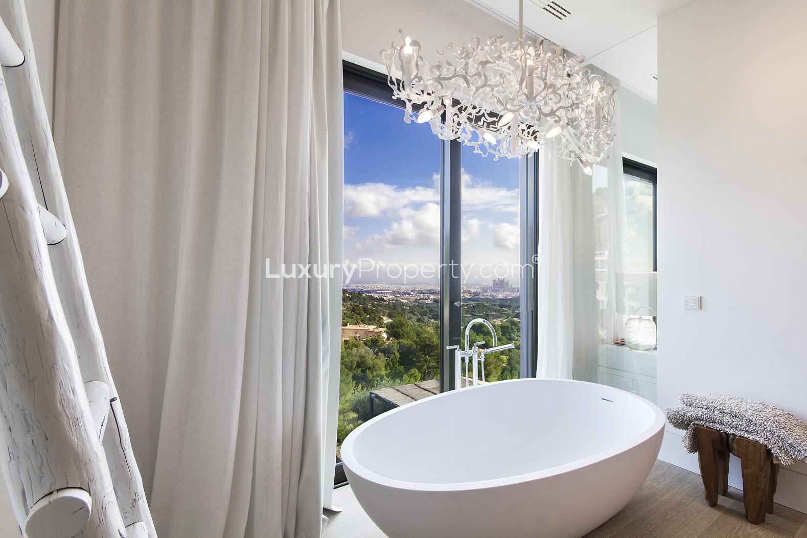 Modern wine cellar in elegant Son Vida villa, Mallorca, featuring wooden shelves and wine bottles