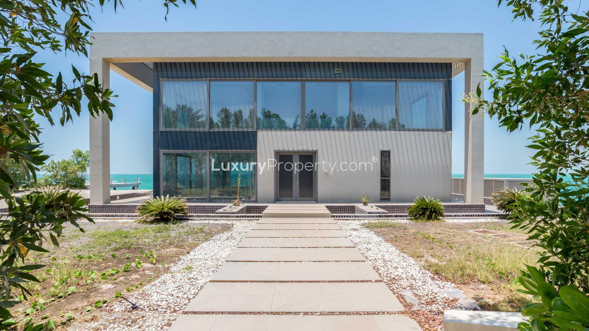 "Stunning ocean view from Zaya Nurai Island villa, lush greenery and turquoise waters.",Majestic beachfront villa exterior on Zaya Nurai Island, featuring modern architecture and sea views