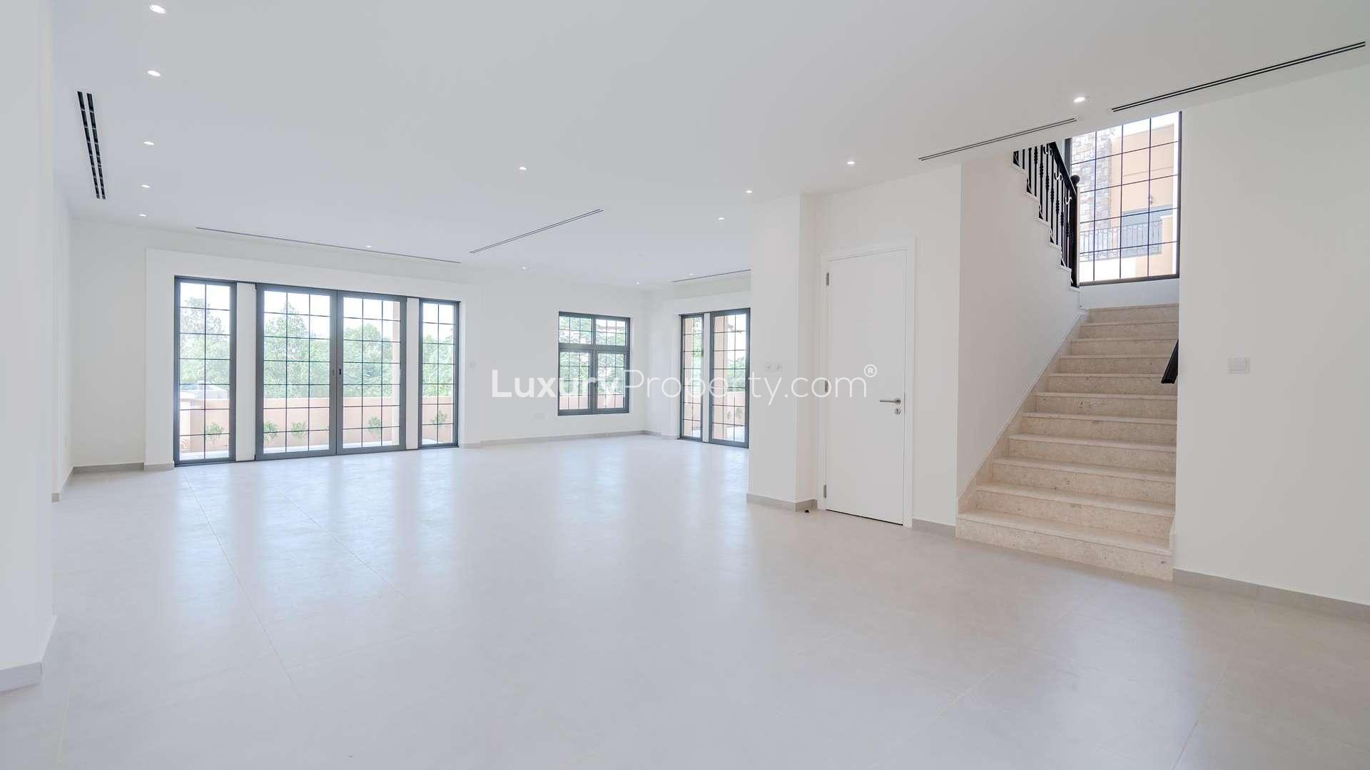 Spacious living room with large windows in Whispering Pines villa, Jumeirah Golf Estates