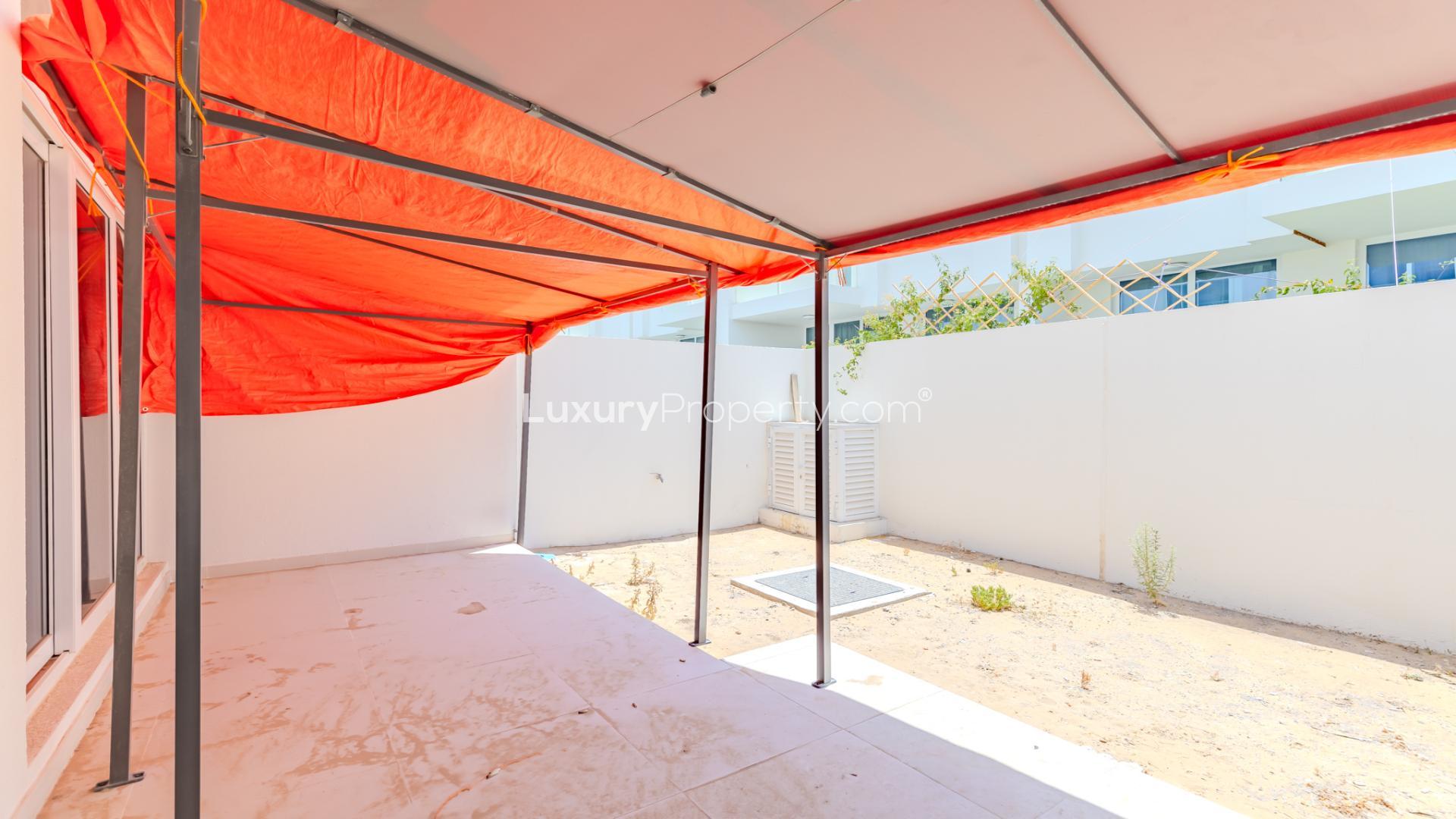 Outdoor patio with red canopy at modern Damac Hills 2 townhouse, Avencia 2