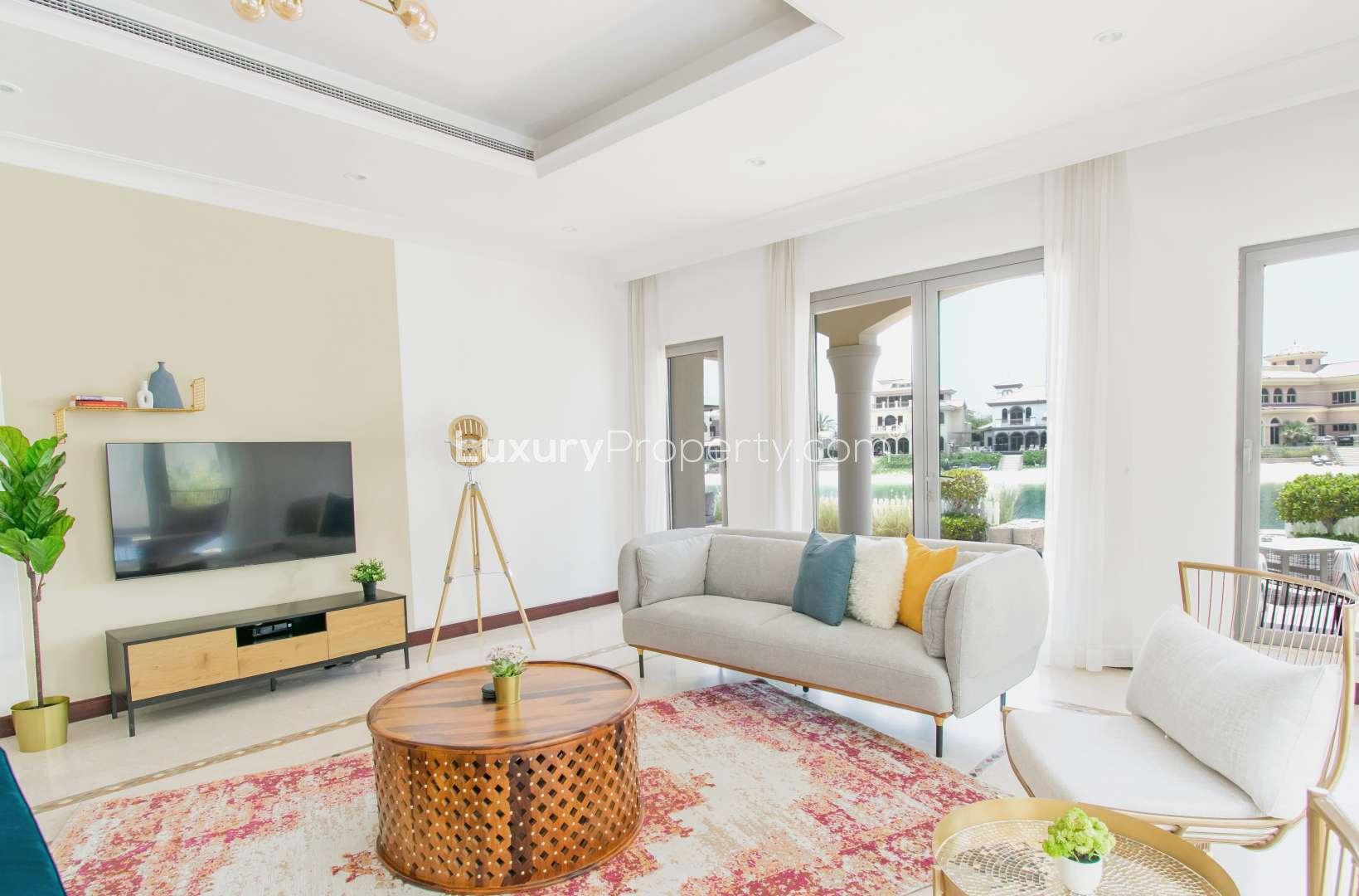 Luxurious living room in furnished Frond Villa, Palm Jumeirah, with elegant decor and garden view