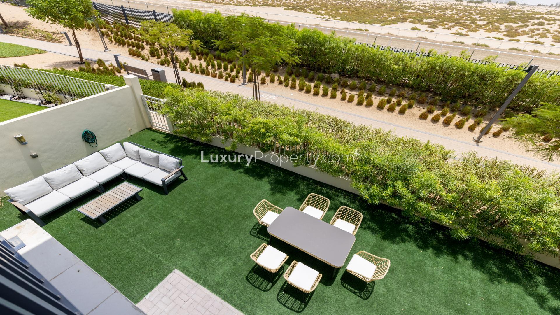 Furnished living room in Maple townhouse, Dubai Hills Estate, with blue sofas and modern decor