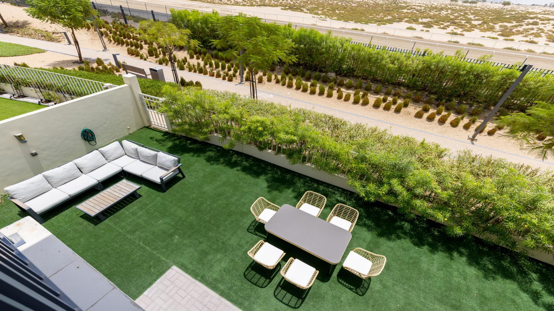 Furnished living room in Maple townhouse, Dubai Hills Estate, with blue sofas and modern decor