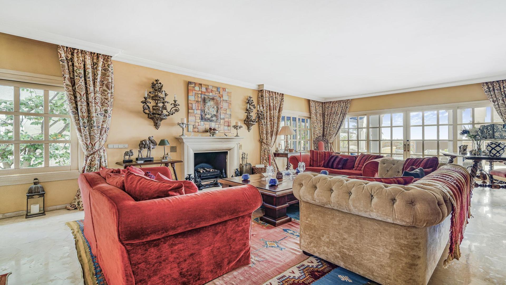 Moorish-inspired villa pool with intricate tiles, palm trees, and sun loungers in Marbella