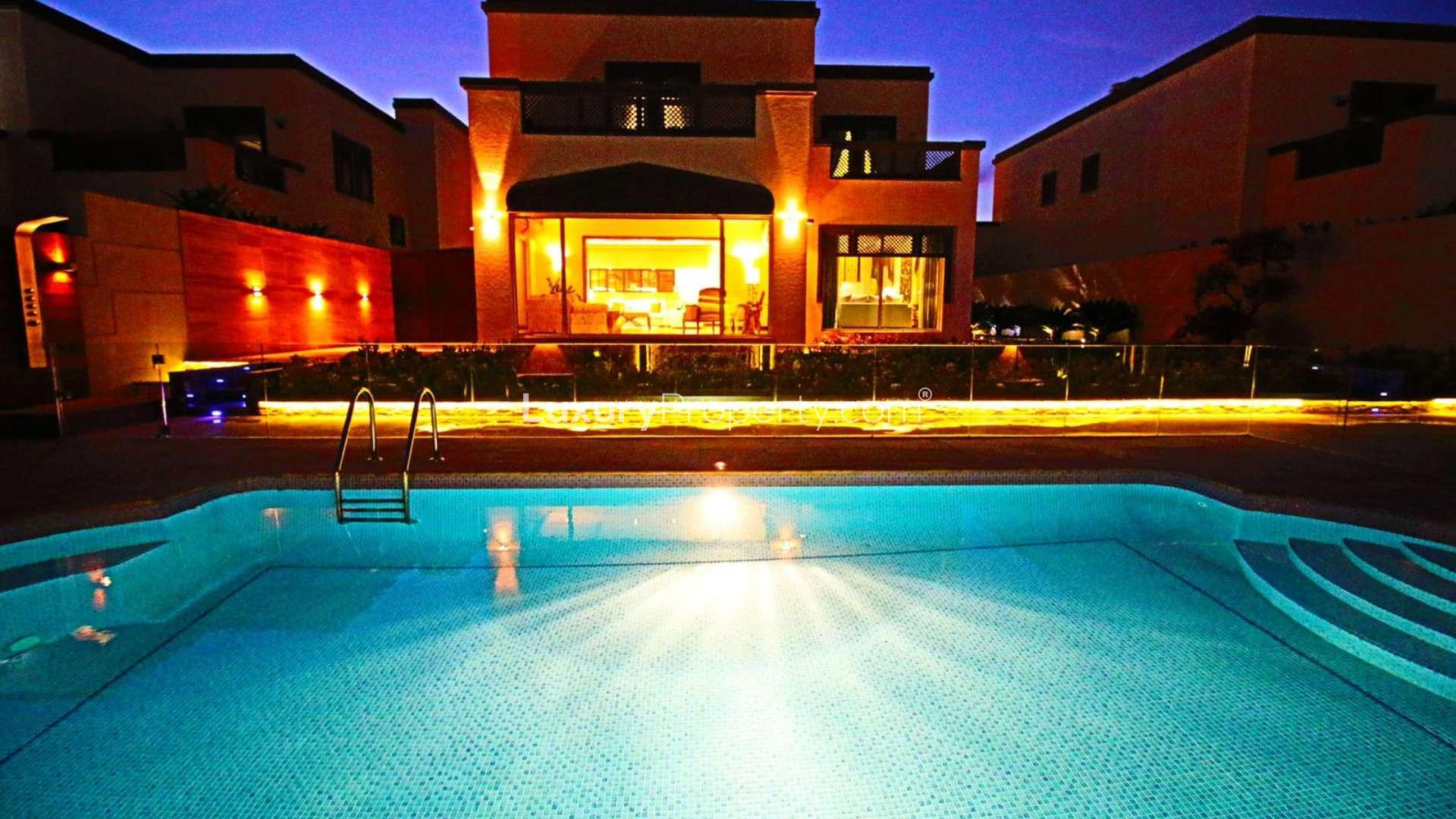 Luxurious living room with large windows overlooking pool in Jumeirah Park villa