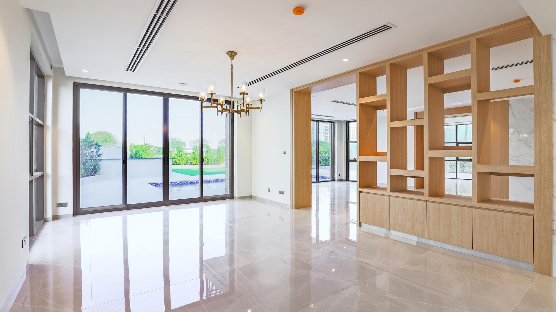 "Spacious upgraded villa interior with marble floors in Jumeirah Golf Estates, Earth sub-community.",Modern living area with large windows and garden view in Jumeirah Golf Estates villa