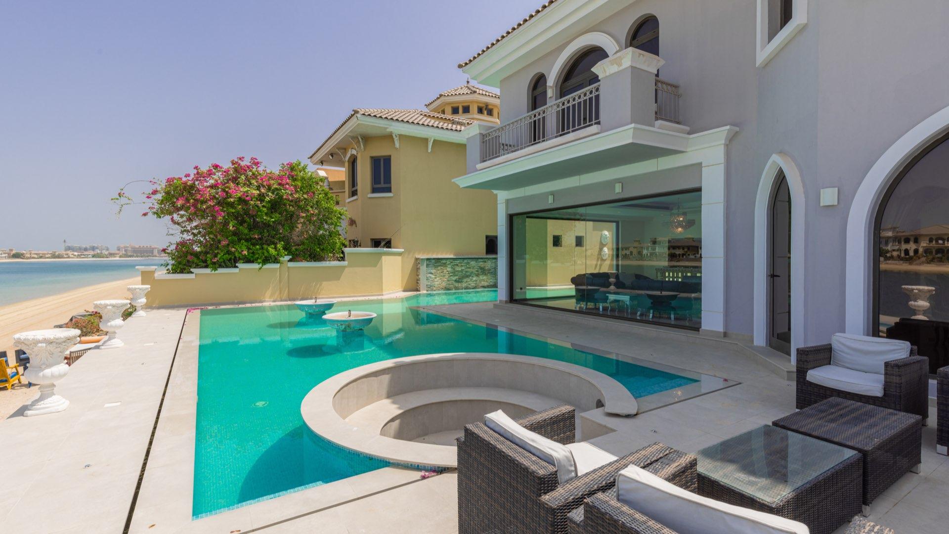 "Luxury villa pool with stunning waterfront views in Palm Jumeirah, Garden Homes.",Luxurious Palm Jumeirah villa with pool, beachfront, and stunning Royal Atlantis views