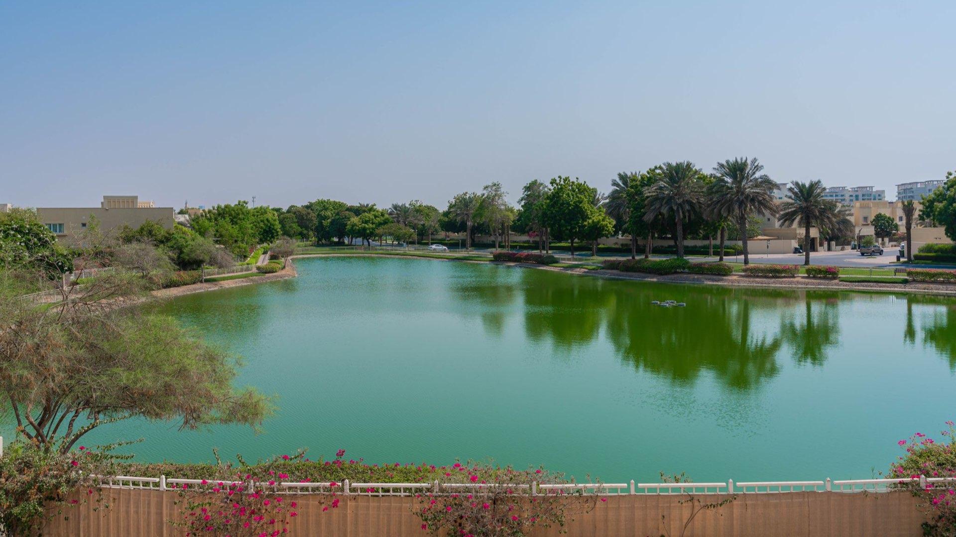 Lake view from spacious villa balcony in Meadows 2, Dubai, overlooking skyline