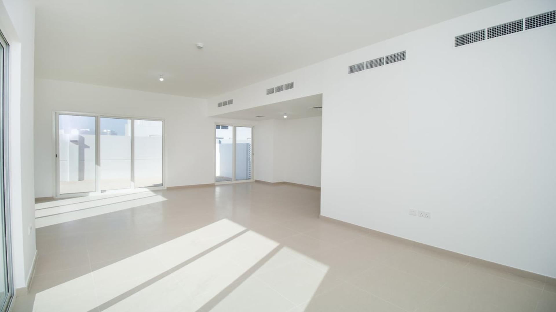 Bright, spacious living area in Arabella Townhouses 2, Mudon, with large windows and natural light