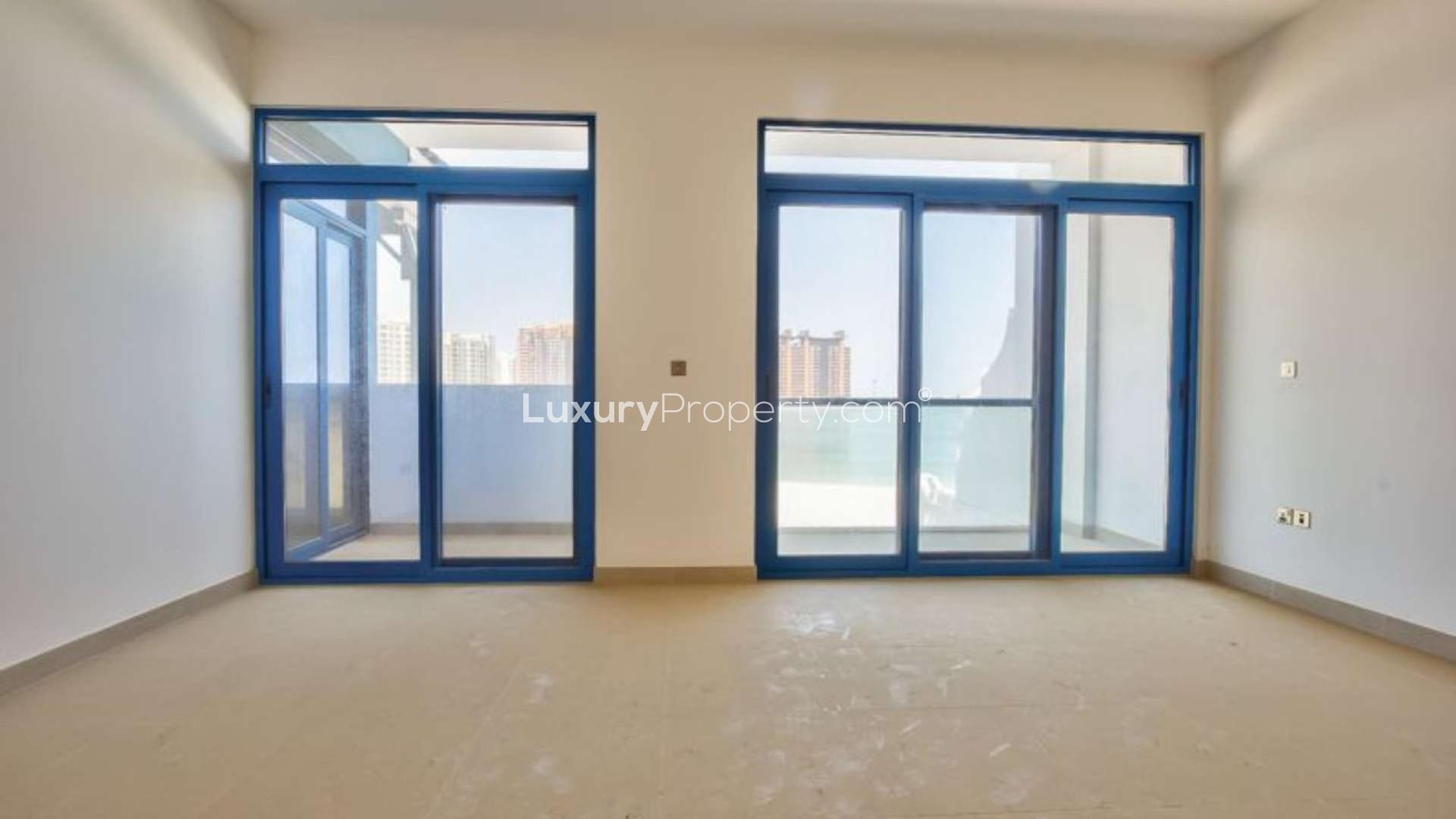 "Stunning sea view from Palma Residences townhouse, Palm Jumeirah beachfront location.",Empty room with large windows offering sea views in Palma Residences townhouse