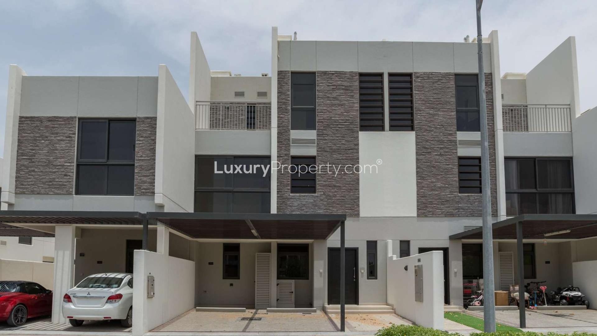 Modern kitchen in five-bedroom villa, Claret, Damac Hills 2, with sleek countertops and staircase view
