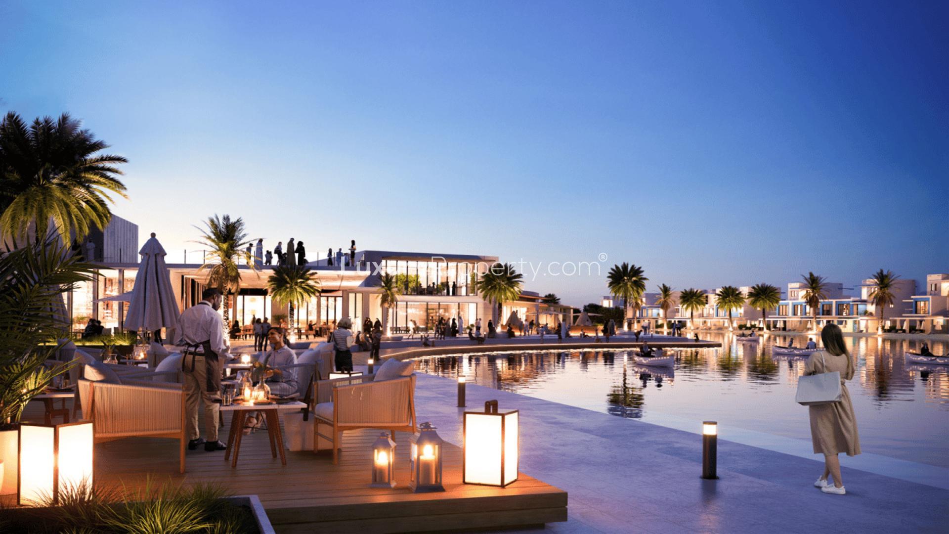 Twilight view of waterfront dining and leisure area at Damac Lagoons townhouse community