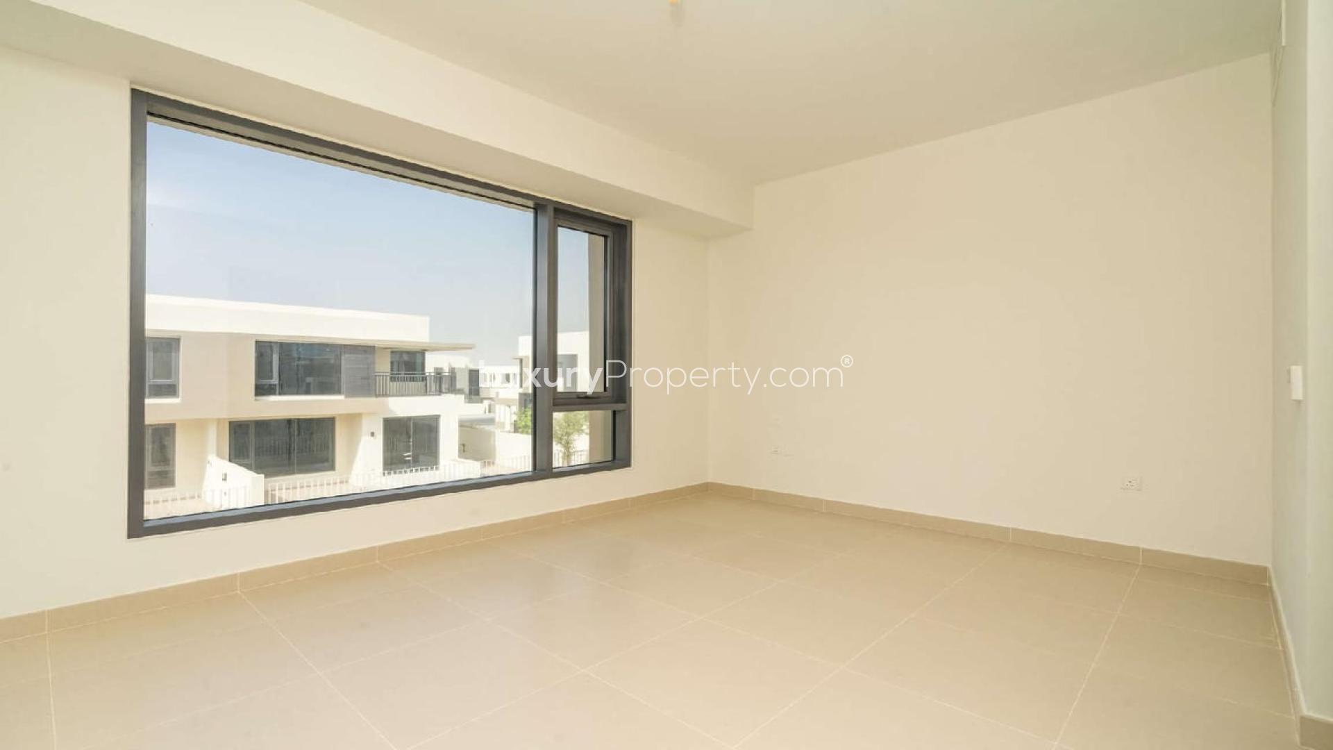 Modern living room in 5-bedroom villa, Dubai Hills Estate, featuring large windows and sleek design
