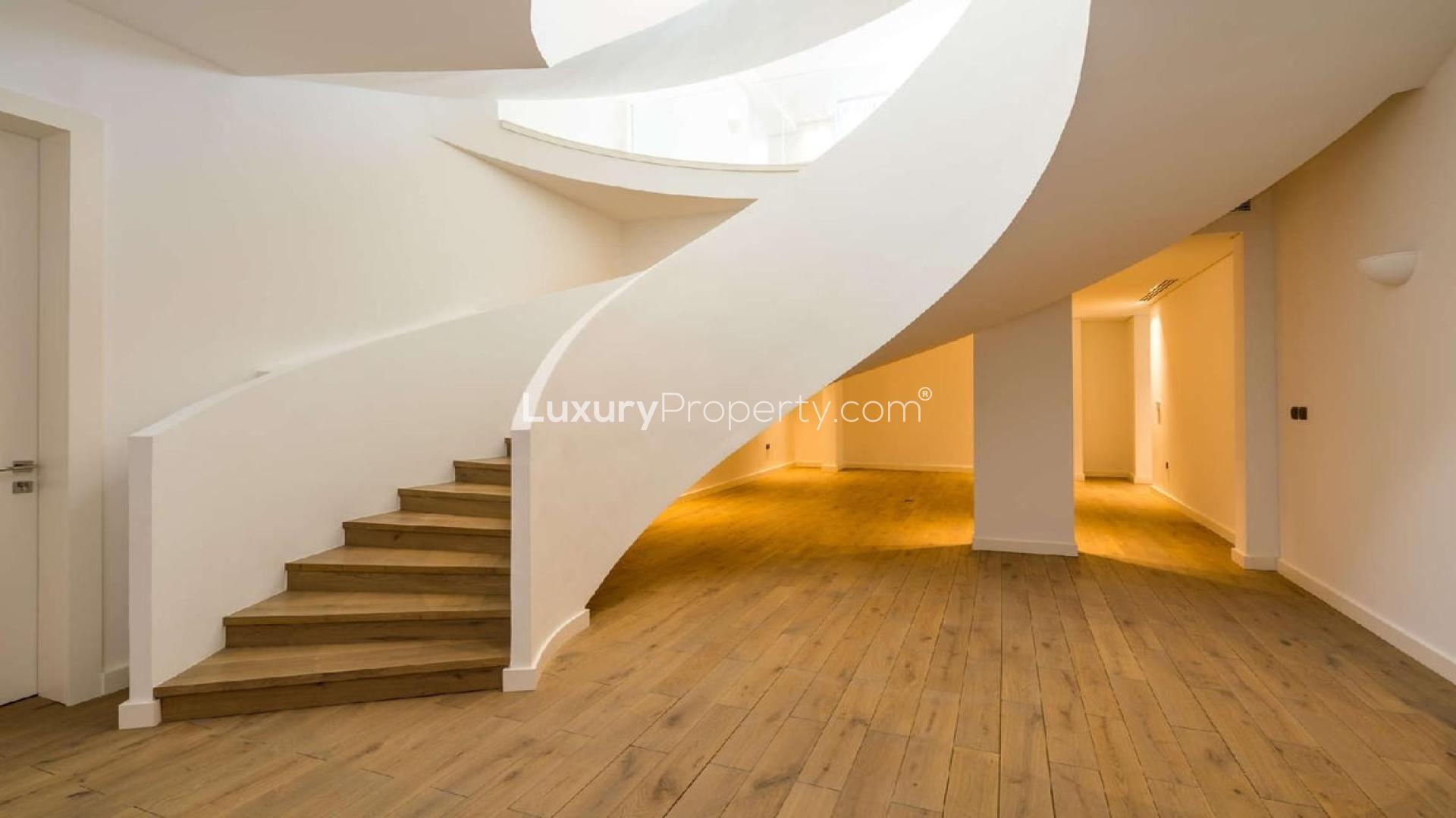 Luxurious villa interior with spiral staircase and pool view in Jumeirah Golf Estates, Dubai