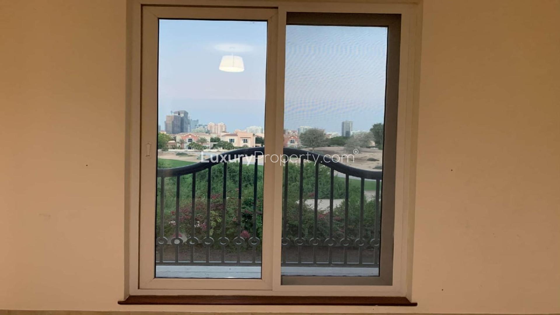 Empty room in 5-bedroom villa, Victory Heights, Dubai, with large windows and garden view