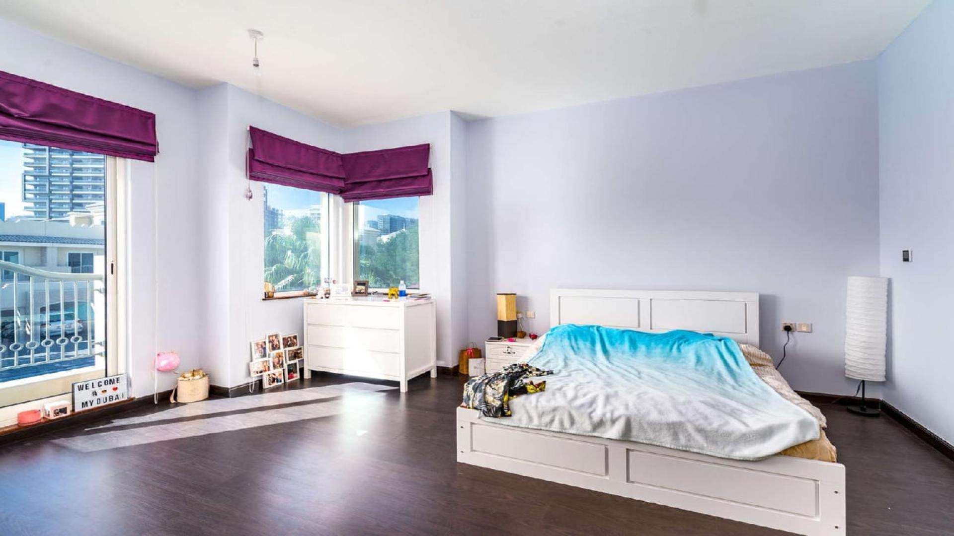 Luxurious living room in 5-bedroom villa, Victory Heights, Dubai, with modern decor and large TV