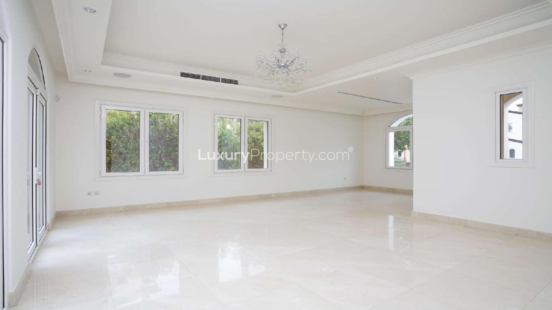 Modern kitchen in Jumeirah Golf Estates villa with lake view, featuring sleek dark cabinetry