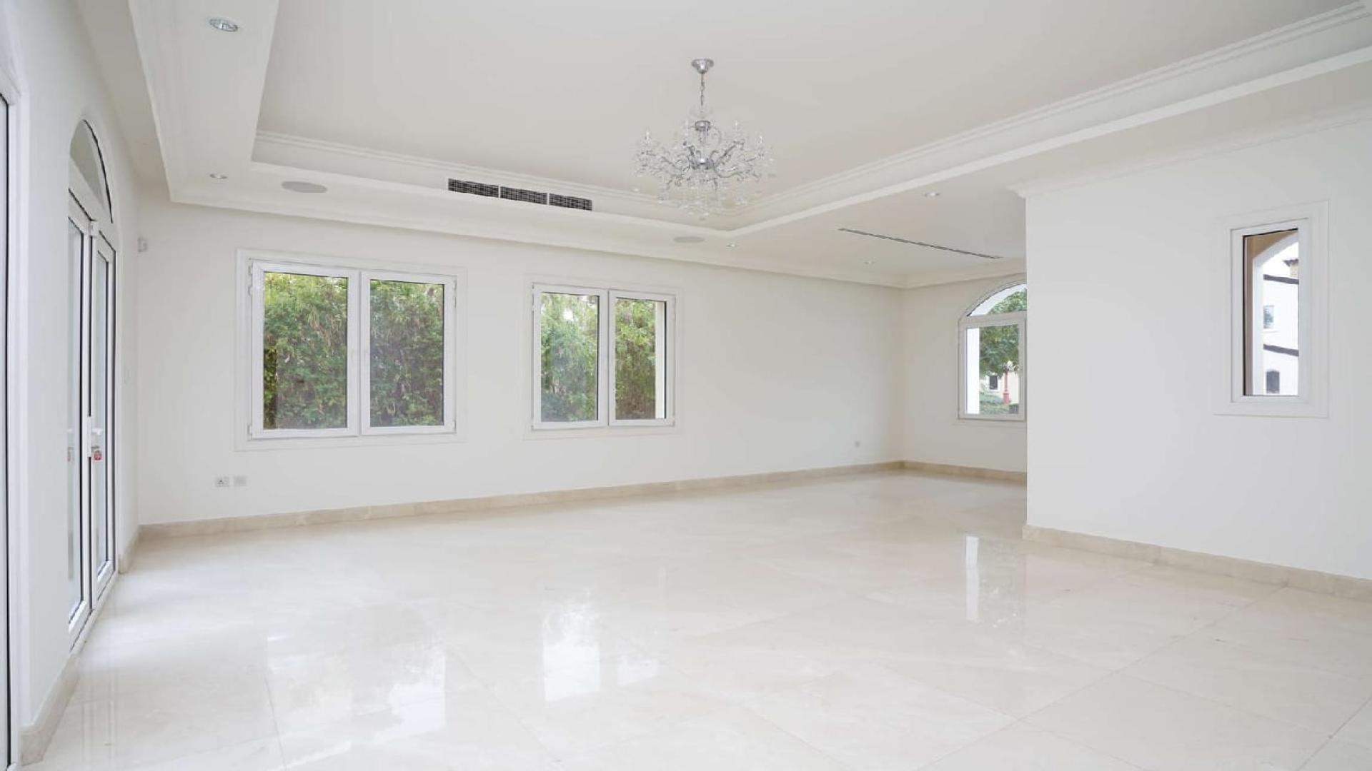 Modern kitchen in Jumeirah Golf Estates villa with lake view, featuring sleek dark cabinetry