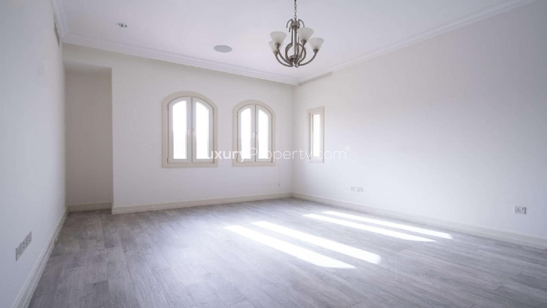 Spacious living area in modern Jumeirah Golf Estates villa with elegant chandeliers