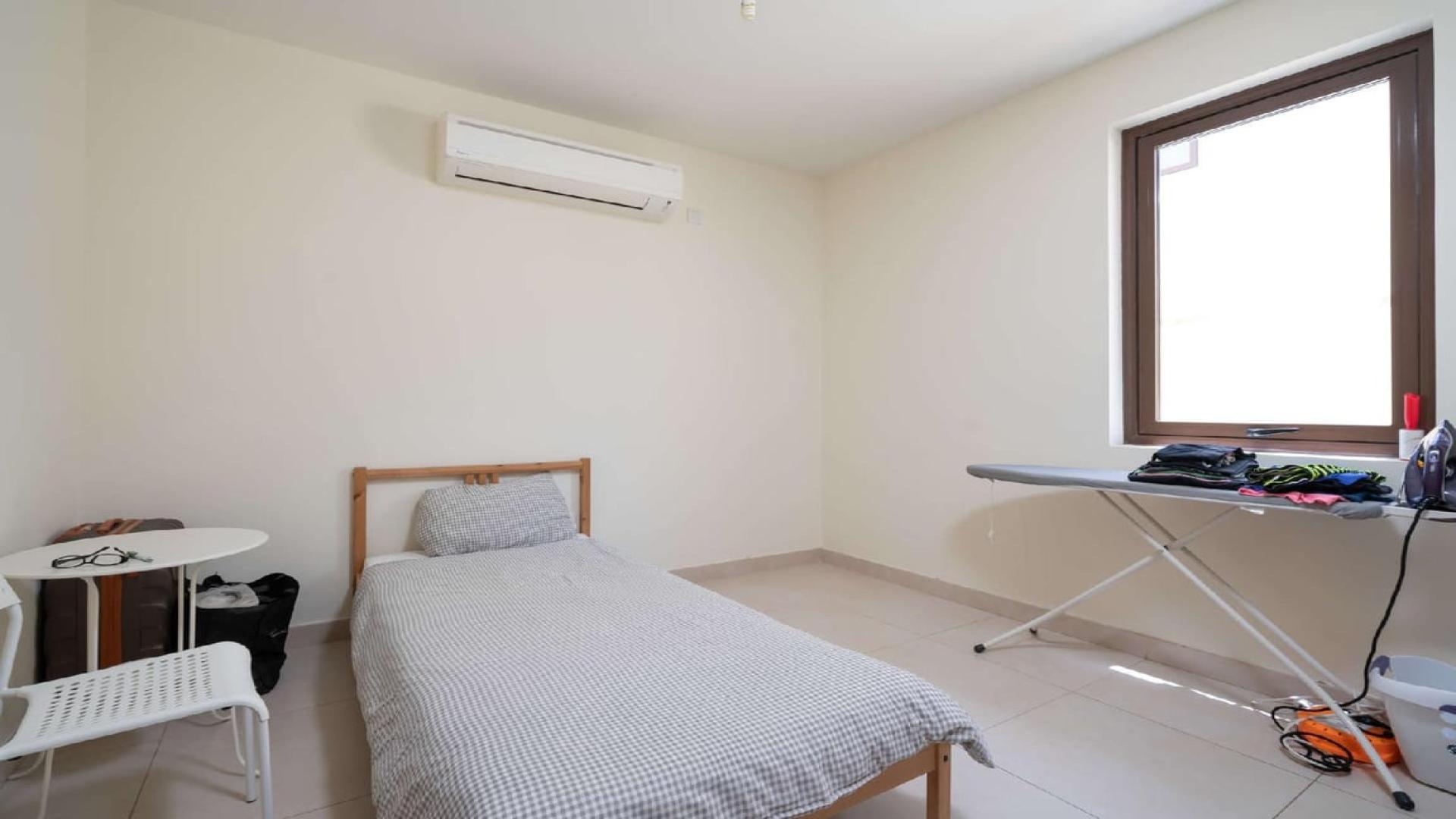 "Elegant 5-bedroom villa exterior in Palma, Arabian Ranches 2, with lush greenery and garage.",Single bedroom with air conditioning in Palma villa, Arabian Ranches 2, for rent