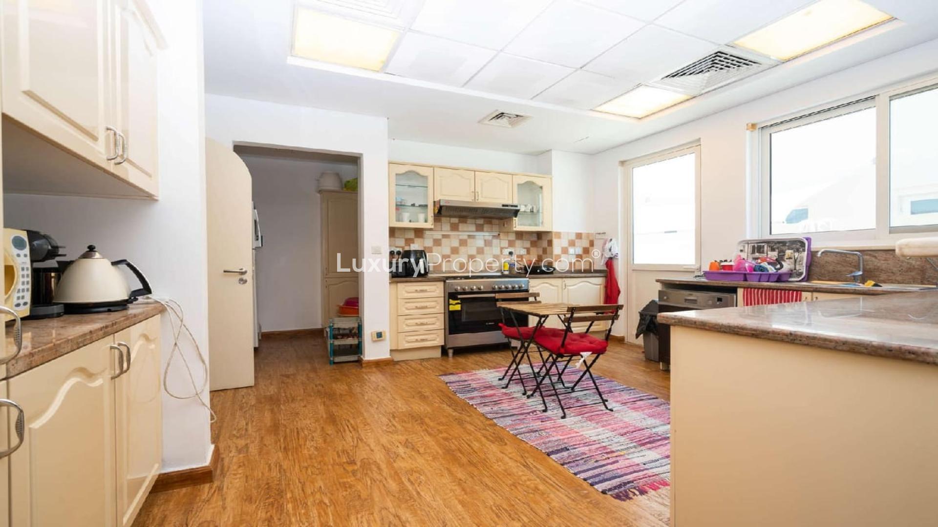 Cozy kitchen in Victory Heights villa, featuring wooden floors and modern appliances