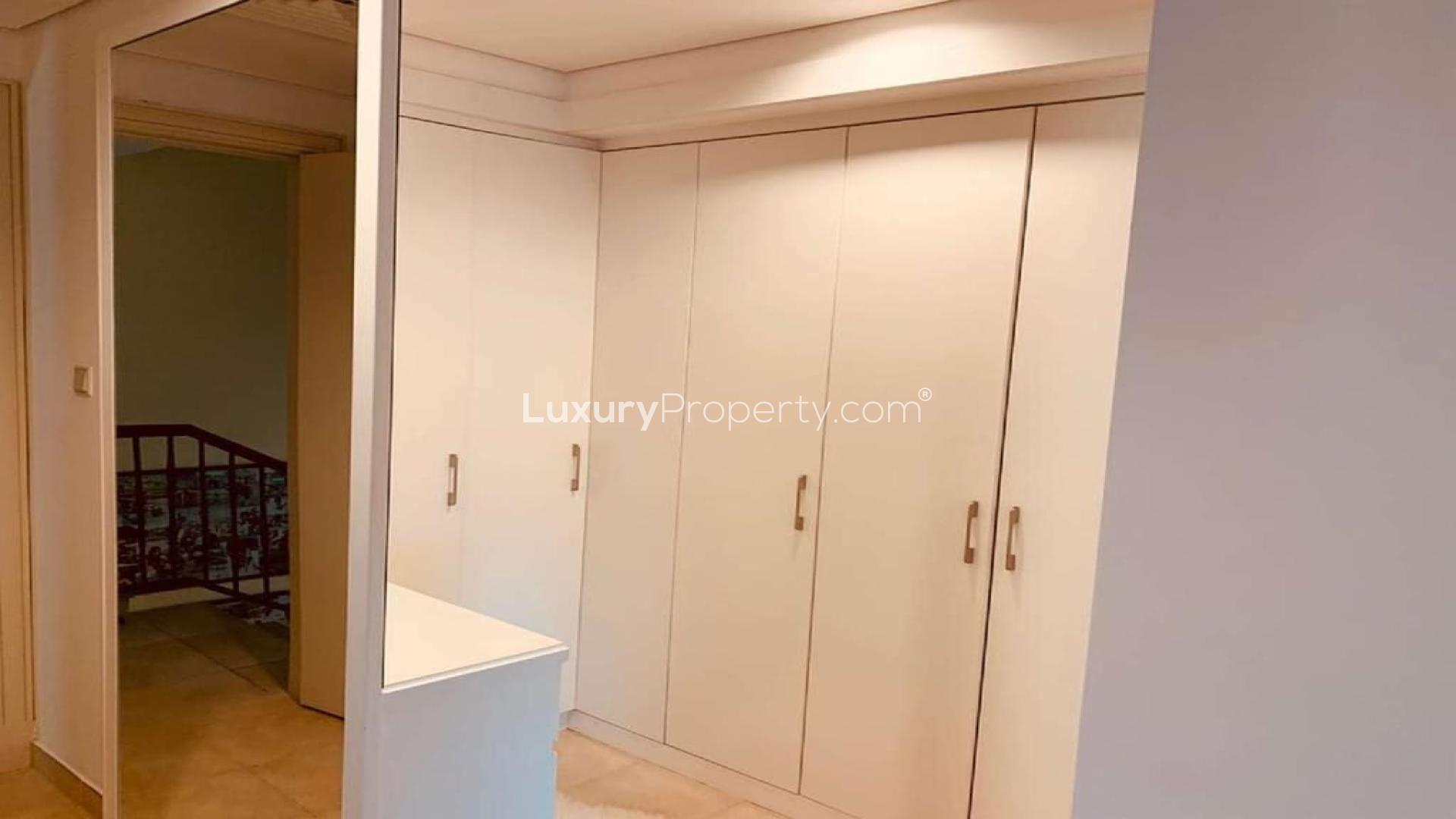 Outdoor pool area with lounge chairs and greenery at Victory Heights villa in Dubai