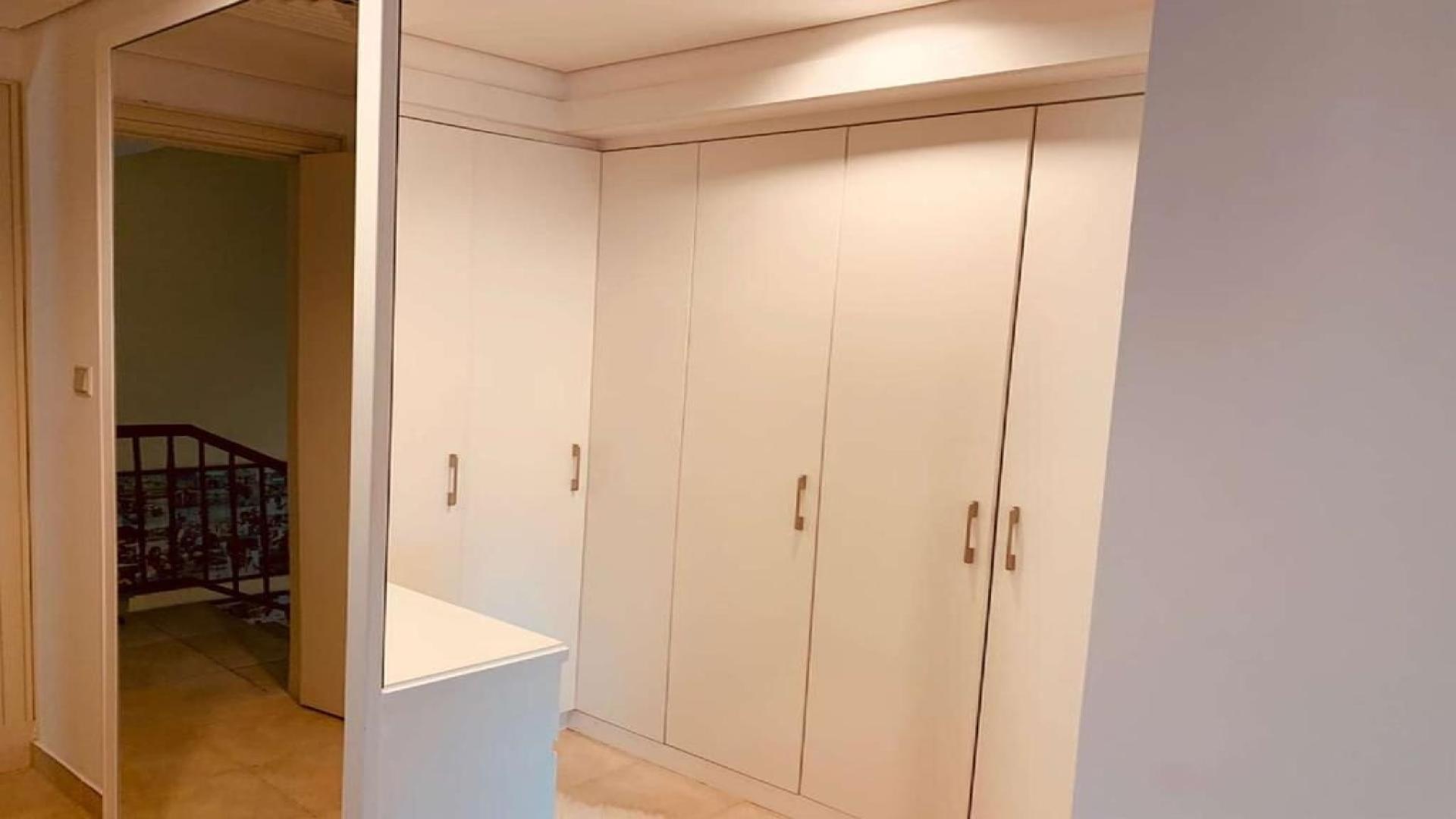 Outdoor pool area with lounge chairs and greenery at Victory Heights villa in Dubai