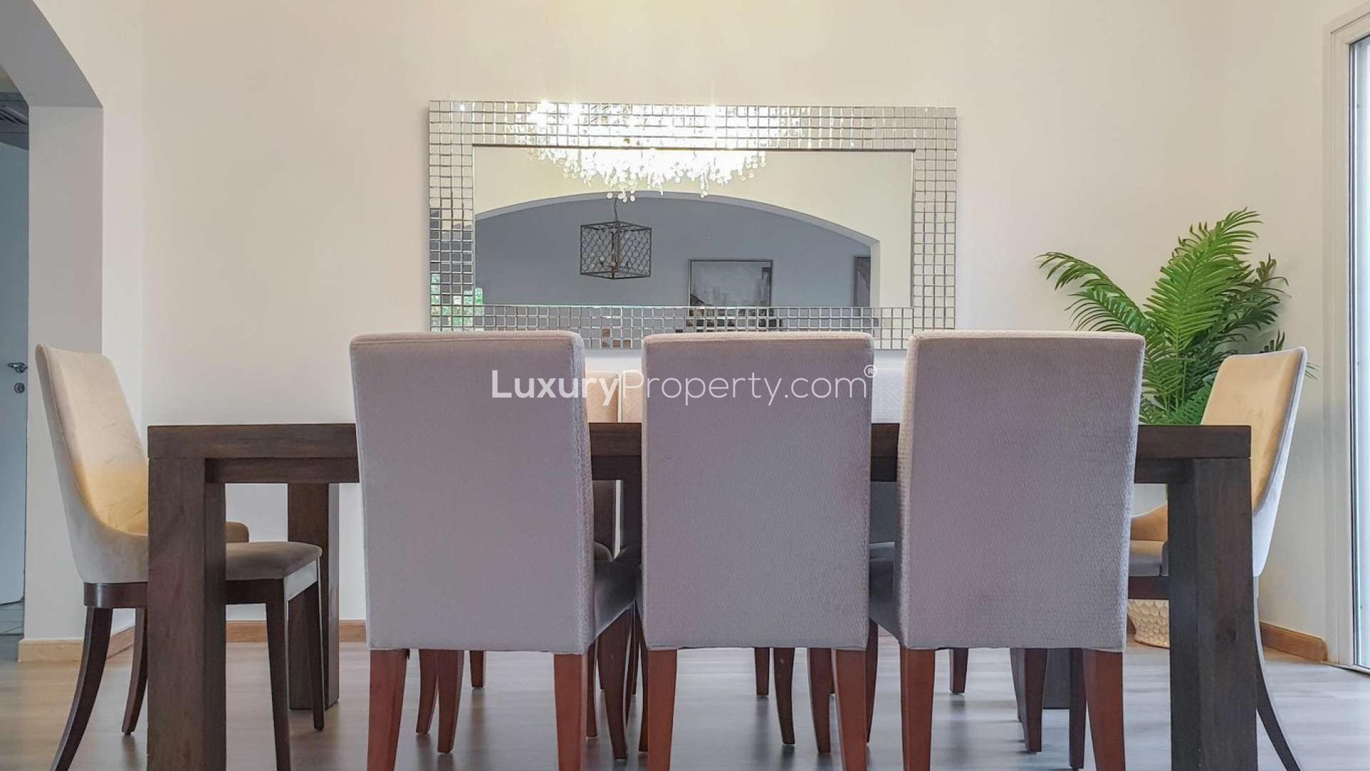 Outdoor seating area in lush garden of five-bedroom villa in Meadows 2 for rent