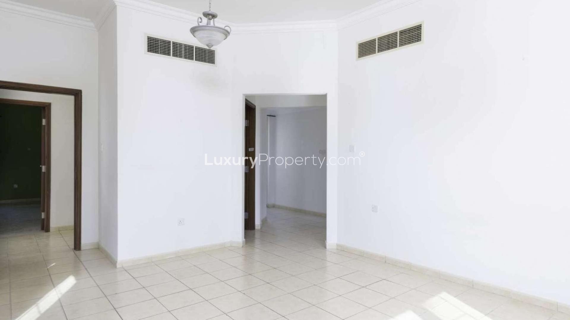 "Elegant staircase in Jumeirah Islands villa, European Clusters, spacious interior, natural light.",Empty living room in Jumeirah Island villa with tiled floors and white walls