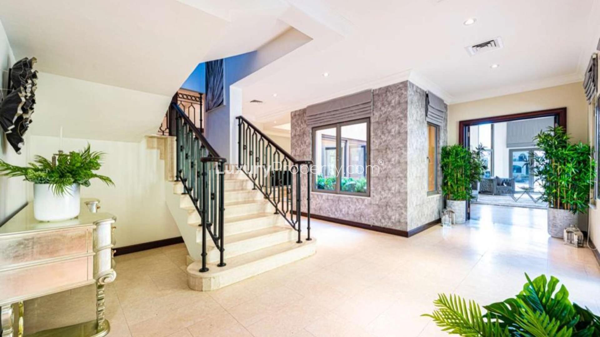 Modern upgraded villa on Palm Jumeirah Frond B, featuring elegant architecture and palm trees